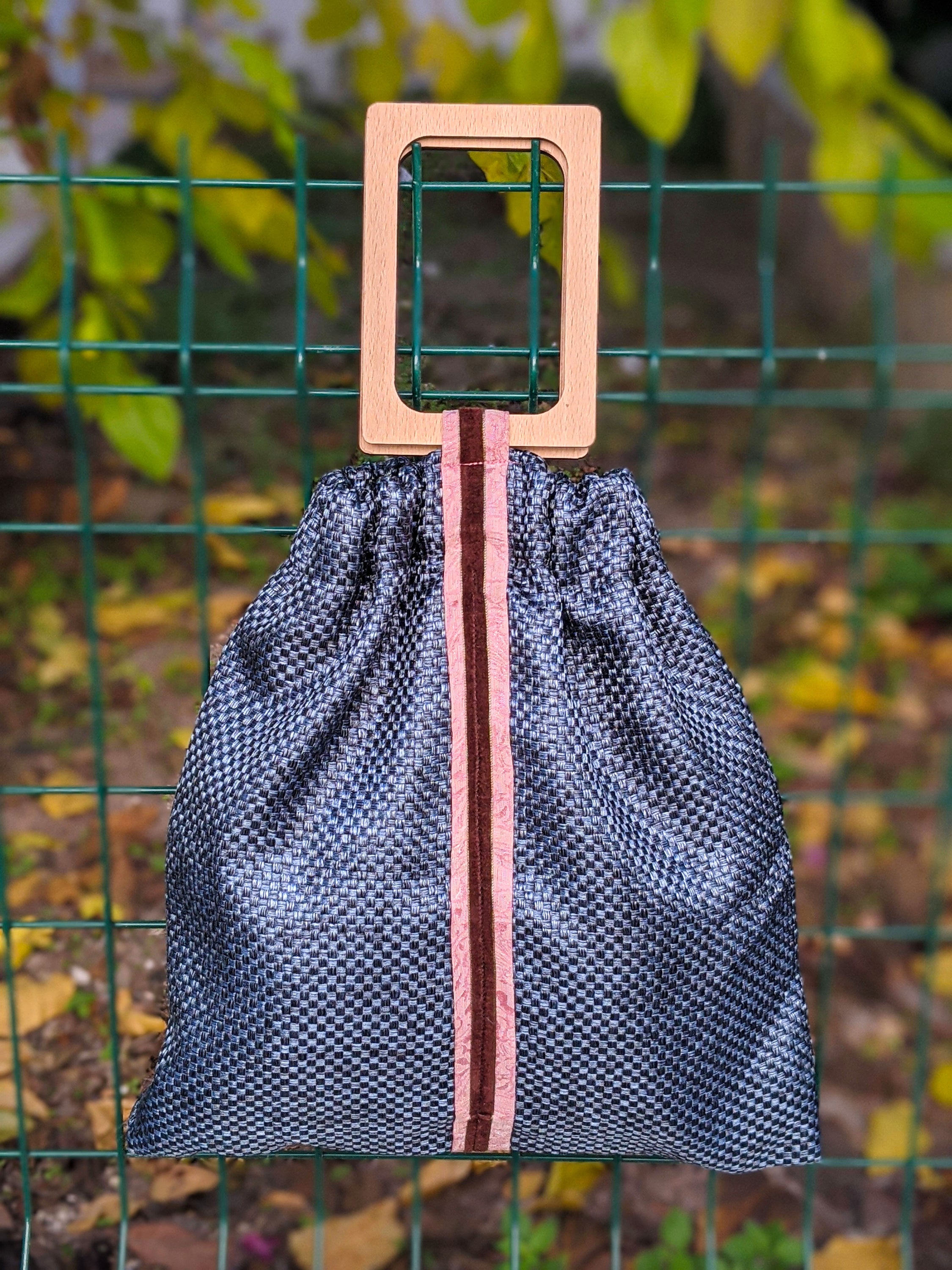 Wonderstone Jasper reversible pouch bag featuring navy blue cloth, ice blue lining, sateen and velvet stripes, and wooden handles.