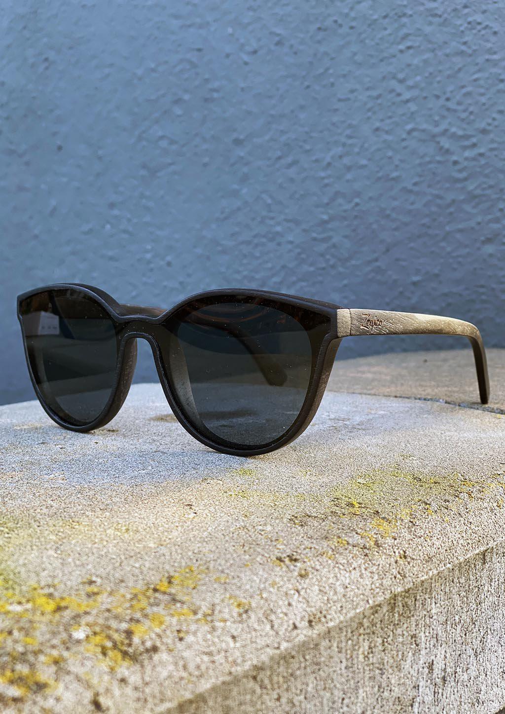 Eyewood Madison sunglasses featuring handcrafted wooden frames and polarized black lenses, elegantly displayed in a handmade empress tree case.