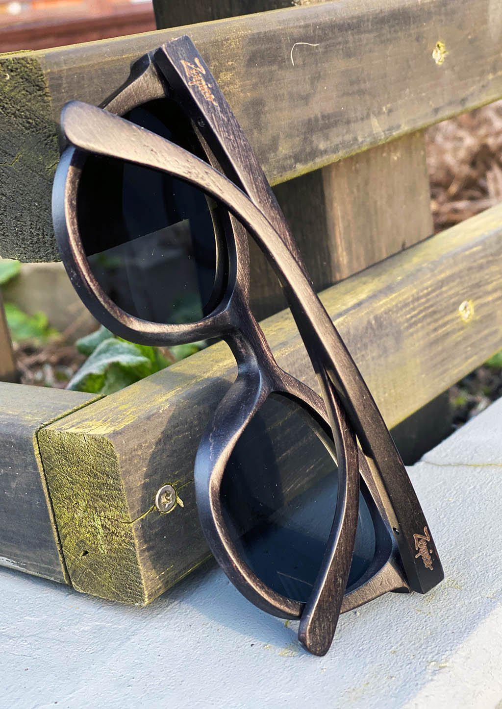 Eyewood Madison sunglasses featuring handcrafted wooden frames and polarized black lenses, elegantly displayed in a handmade empress tree case.