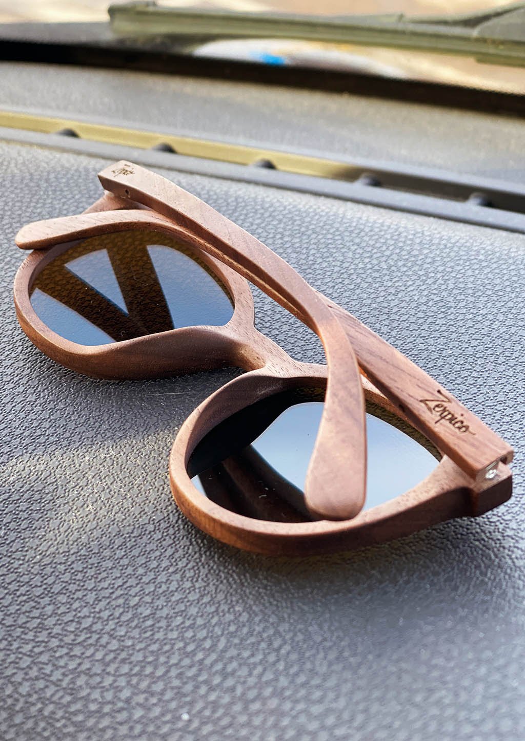 Eyewood Savannah sunglasses featuring a unique wooden frame and blue mirror polarized lenses, elegantly displayed in a handmade empress tree case.