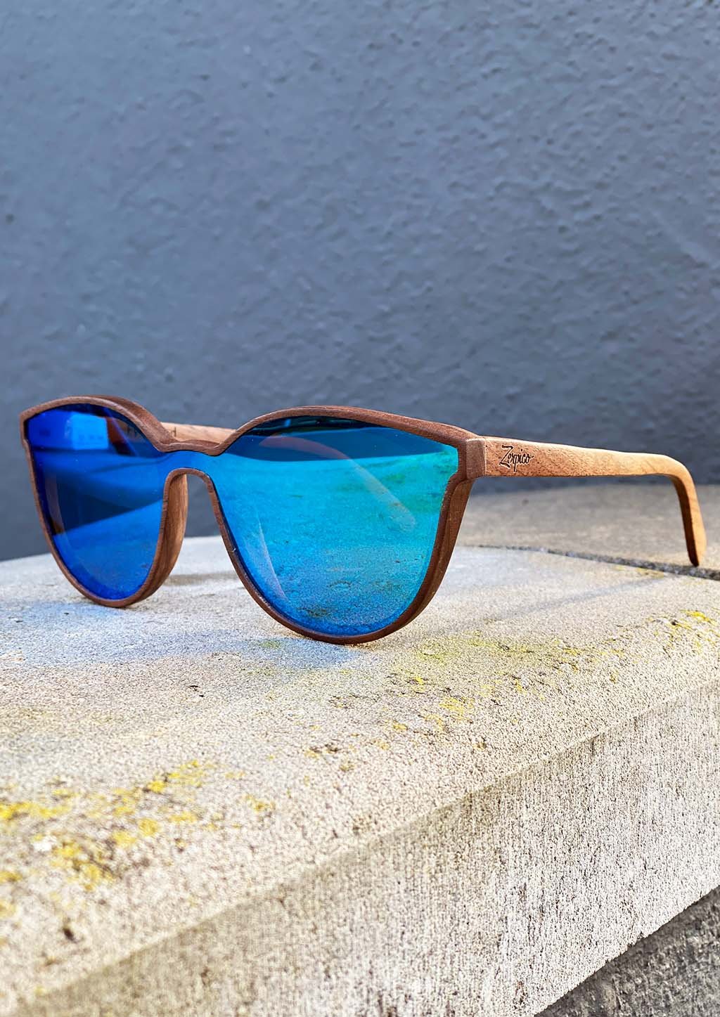 Eyewood Savannah sunglasses featuring a unique wooden frame and blue mirror polarized lenses, elegantly displayed in a handmade empress tree case.