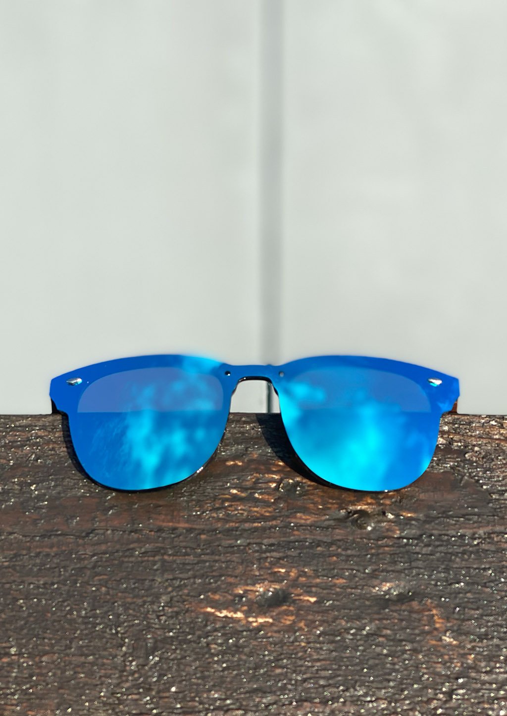 Eyewood Tomorrow - Delphinus wooden sunglasses featuring walnut temples and blue mirror polarized lenses, elegantly displayed in a natural setting.