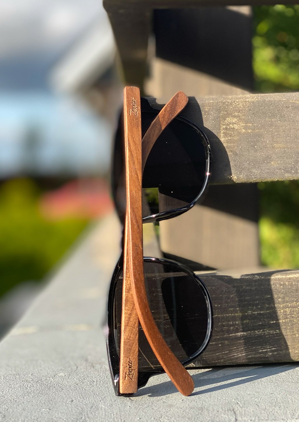 Eyewood Tomorrow - Fornax wooden sunglasses featuring walnut temples and polarized black lenses, elegantly displayed in a natural setting.