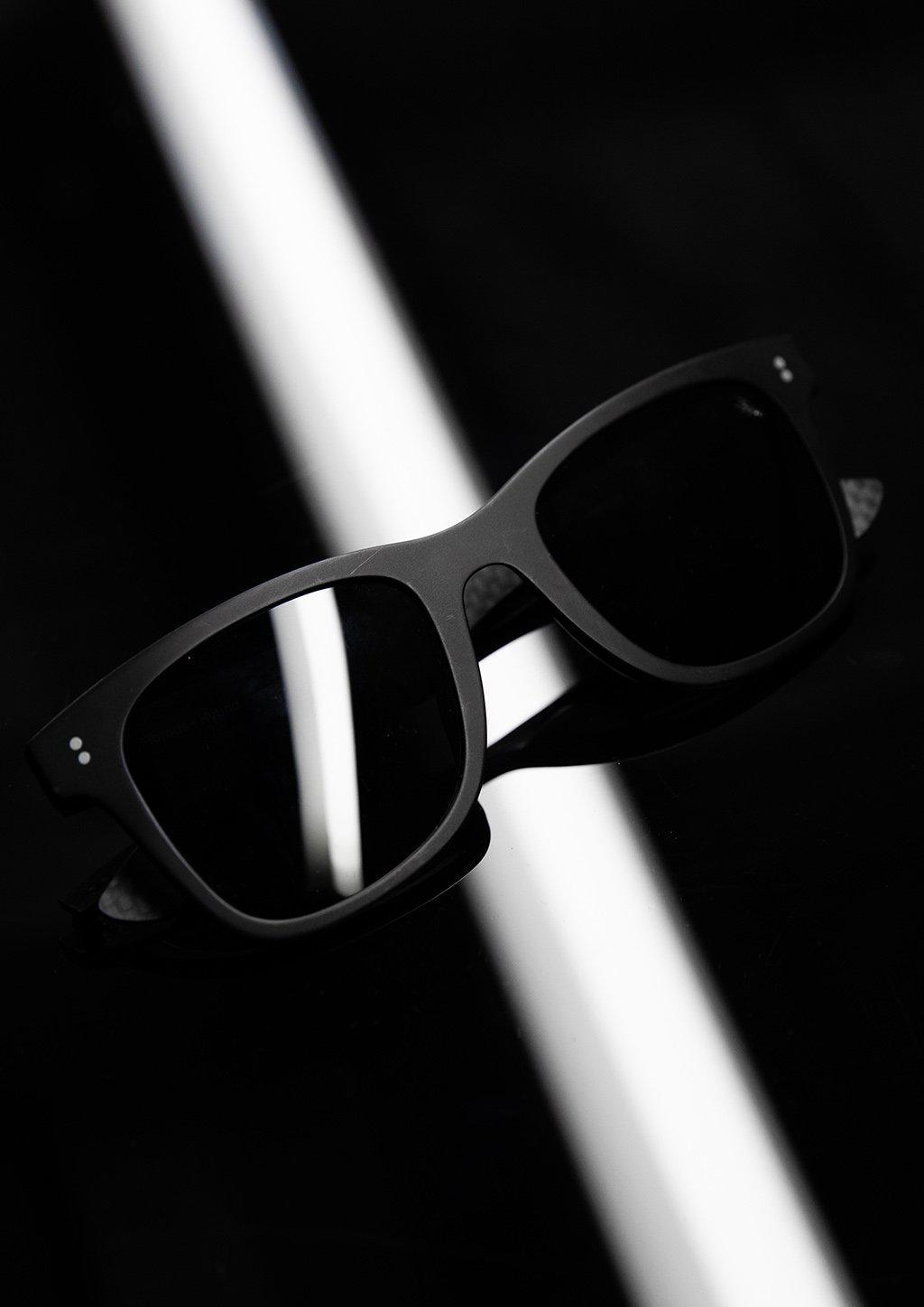 Hybrid Atom sunglasses featuring carbon fiber and acetate materials in a stylish Wayfarer design.