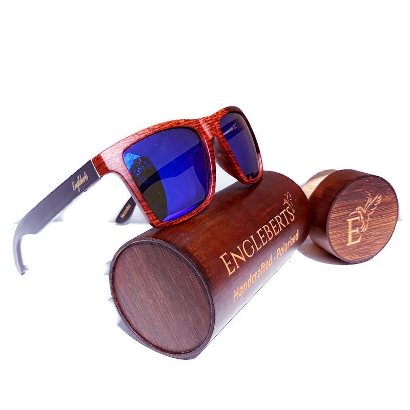 Stylish oak colored bamboo sunglasses with blue polarized lenses, displayed with a bamboo case and accessories.