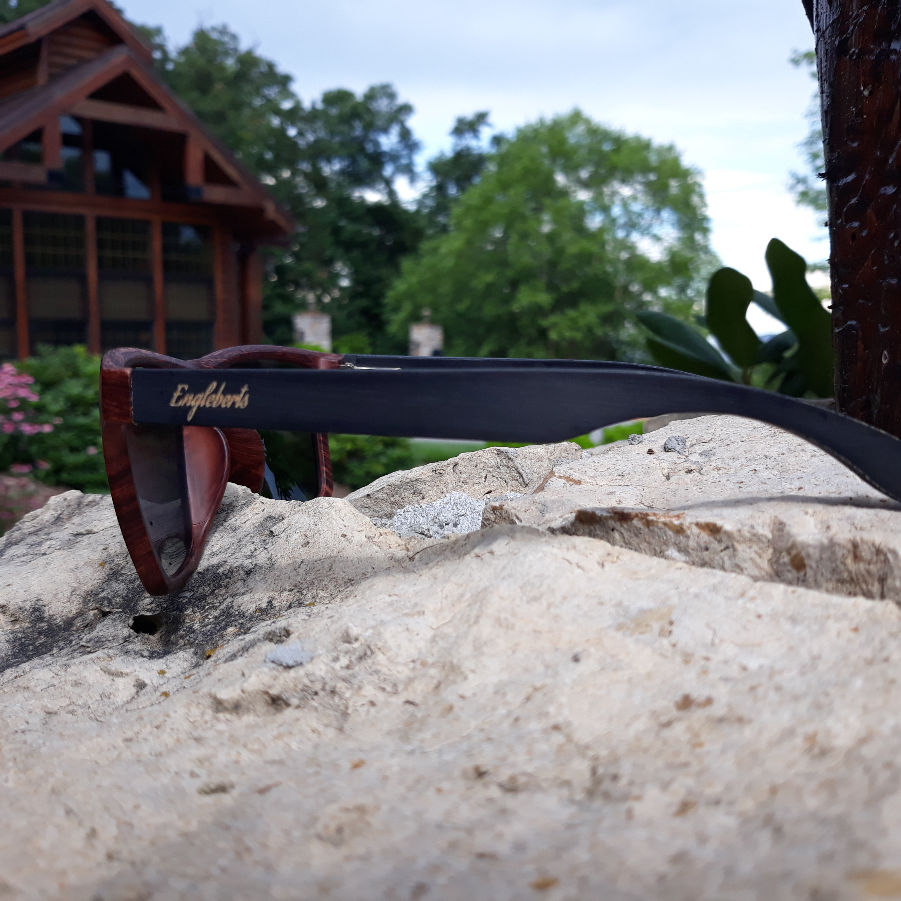 Stylish oak colored bamboo sunglasses with blue polarized lenses, displayed with a bamboo case and accessories.