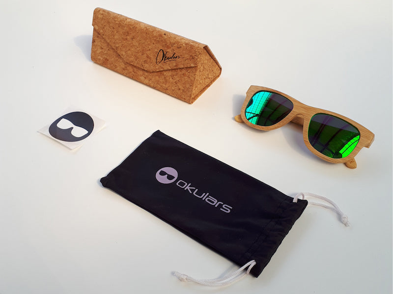 Okulars® Natural Bamboo sunglasses featuring a lightweight bamboo frame and polarized green lenses, elegantly displayed with a cork case.