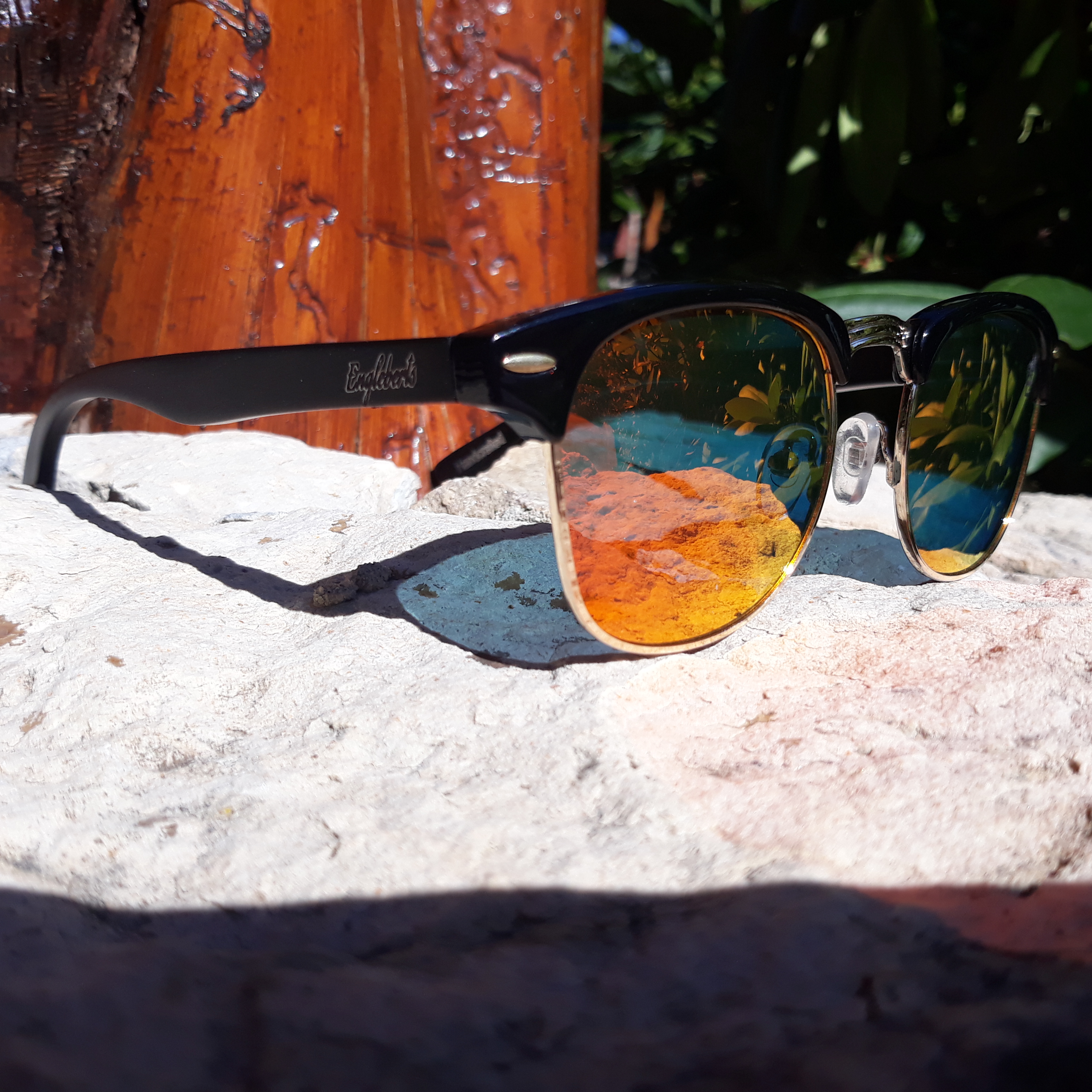 Sunset Polarized Sunglasses made of black bamboo, displayed with a wooden case, showcasing their stylish design and eco-friendly materials.