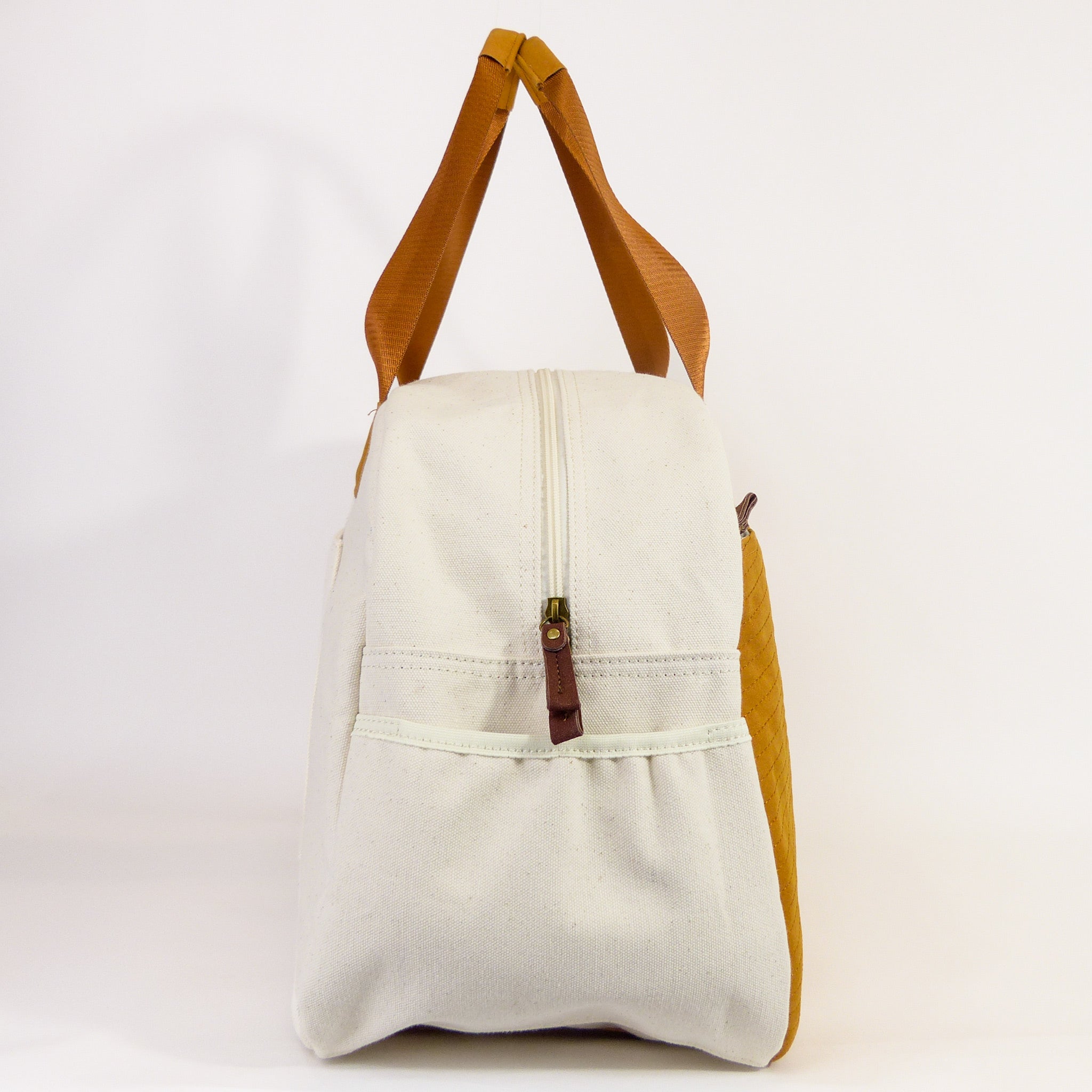 Getaway Duffel Bag in Bliss Curry and Cream color, showcasing its stylish design and spacious compartments for travel.