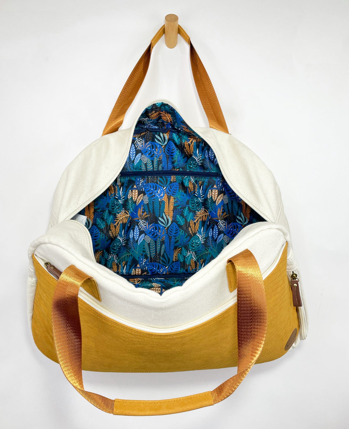 Getaway Duffel Bag in Bliss Curry and Cream color, showcasing its stylish design and spacious compartments for travel.