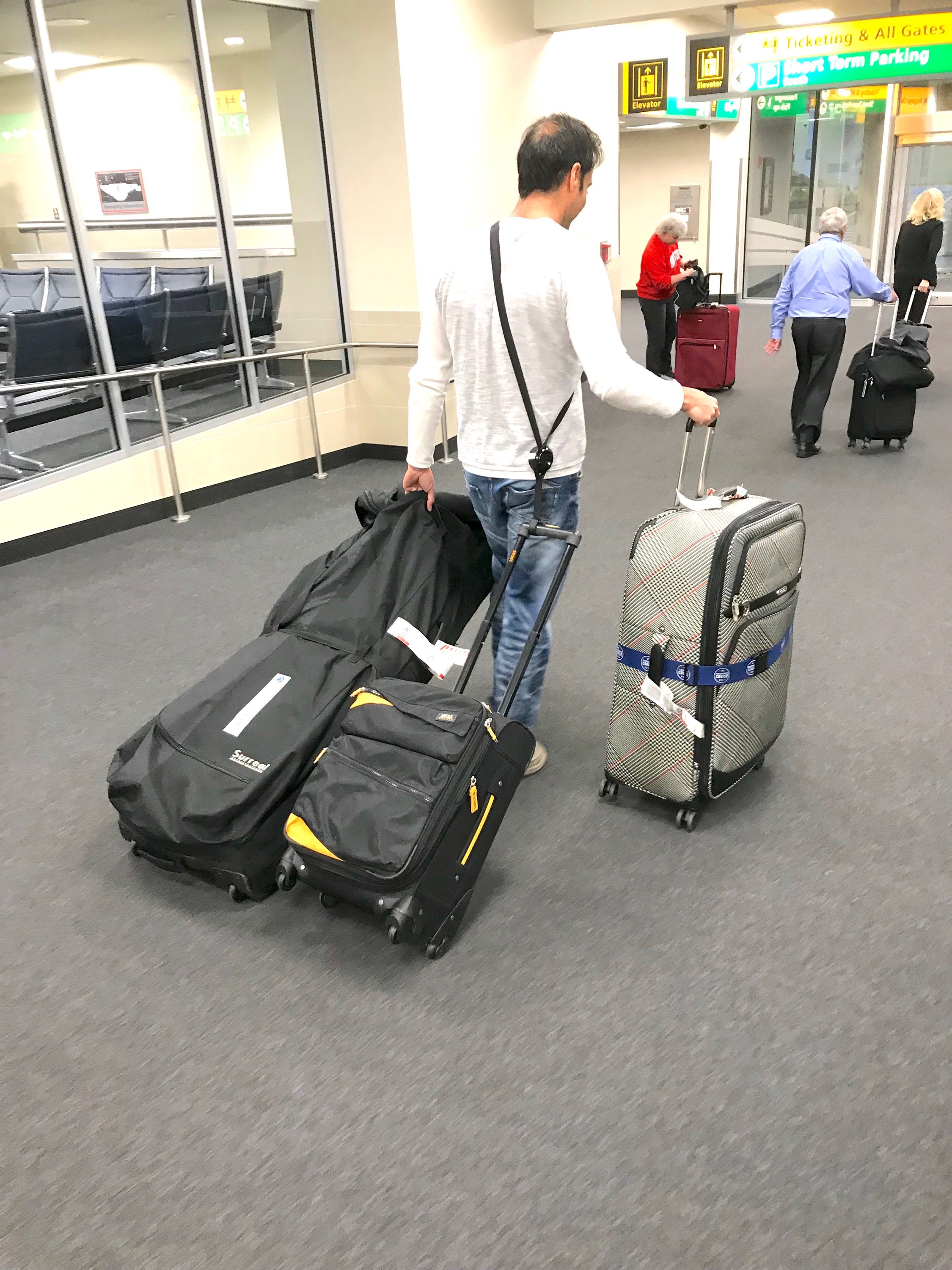 RetraStrap hands-free luggage strap attached to a wheeled carry-on, showcasing its ergonomic design and anti-theft features.