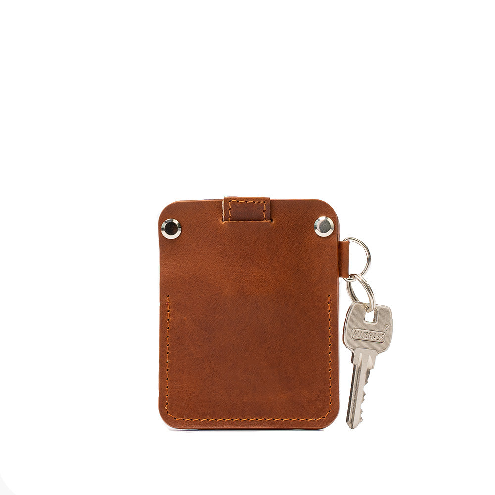 A stylish leather AirTag wallet with D-ring, showcasing its compact design and hidden AirTag pocket, perfect for holding cards securely.