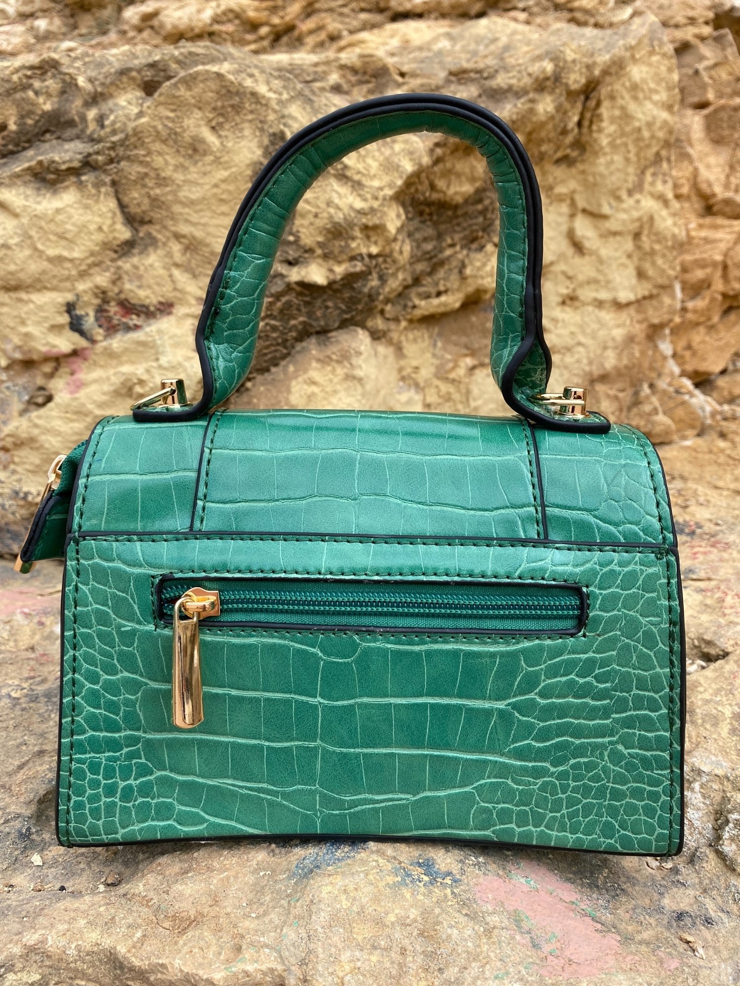 Animal print shoulder bag in green and black with adjustable strap and metallic detail.