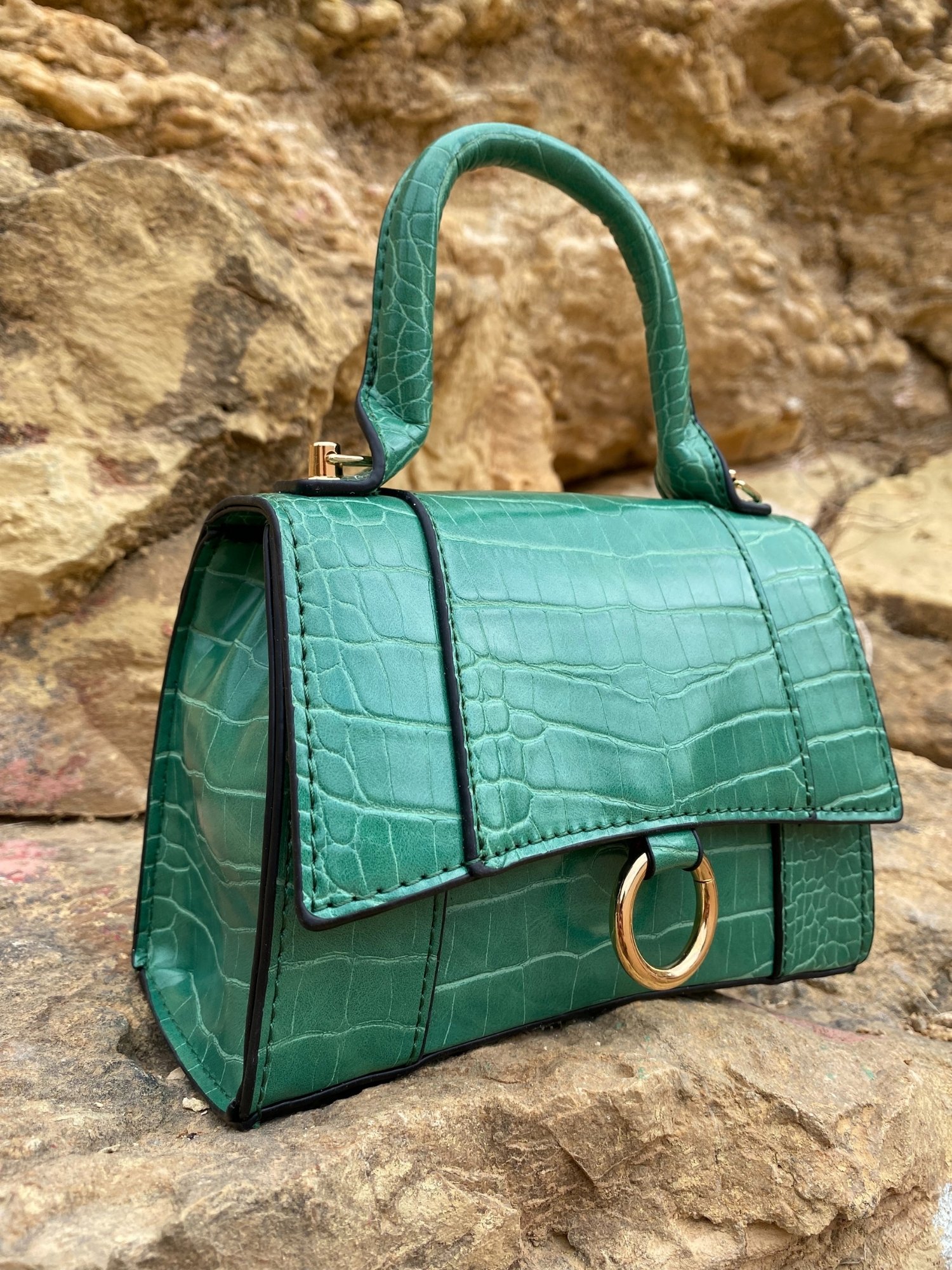 Animal print shoulder bag in green and black with adjustable strap and metallic detail.