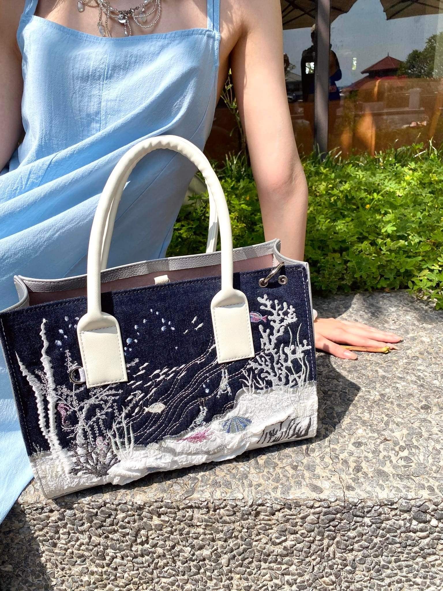 Artbook Medium - Seabed Shoulder Bag featuring unique ocean wave patterns and adjustable handle, made from vegan leather.