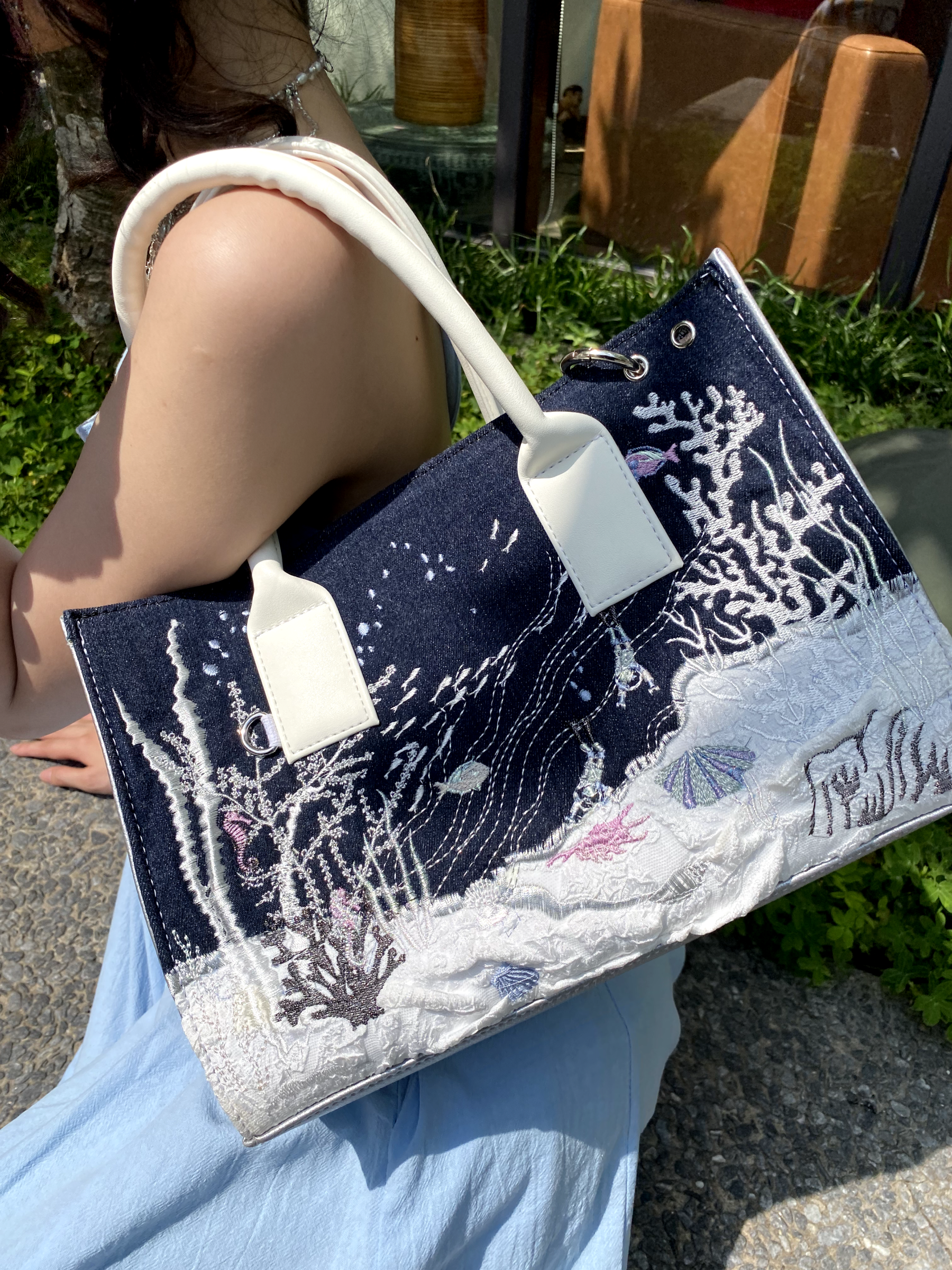 Artbook Medium - Seabed Shoulder Bag featuring unique ocean wave patterns and adjustable handle, made from vegan leather.