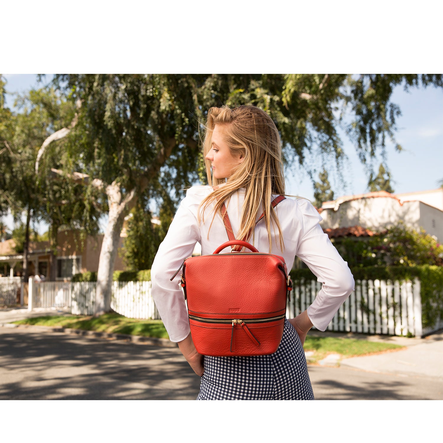 Ashley Red Leather Backpack Purse featuring genuine pebble leather, light gold zippers, and tassels, perfect for stylish everyday use.