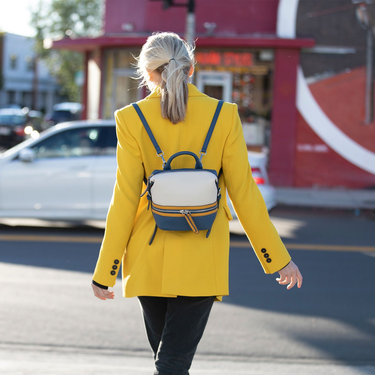 Ashley Small Off White Leather Backpack with silver zippers and tassels, showcasing its stylish design and practical features.