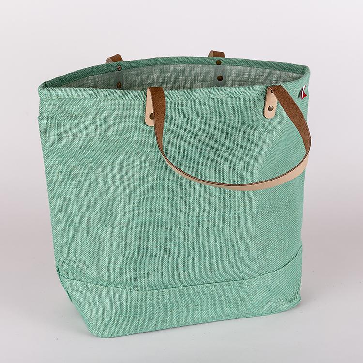 A vibrant Big Jute Colored Tote Bag with leather handles, showcasing its spacious interior and stylish design, perfect for errands and outings.