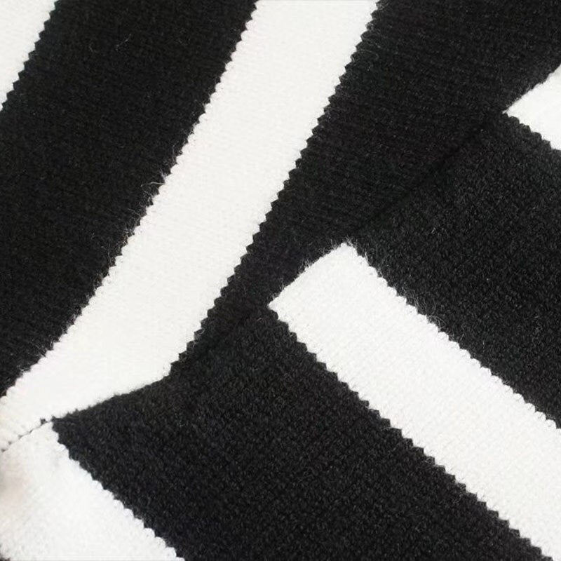 A stylish black and white striped knitted sweater with a turtleneck, perfect for autumn and winter wear.