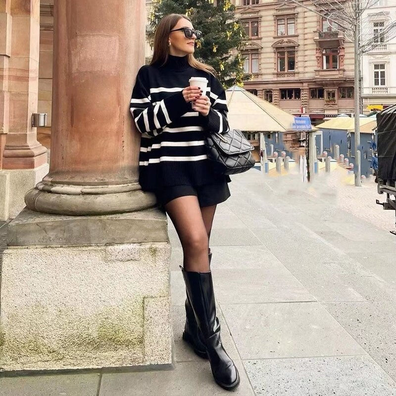 A stylish black and white striped knitted sweater with a turtleneck, perfect for autumn and winter wear.