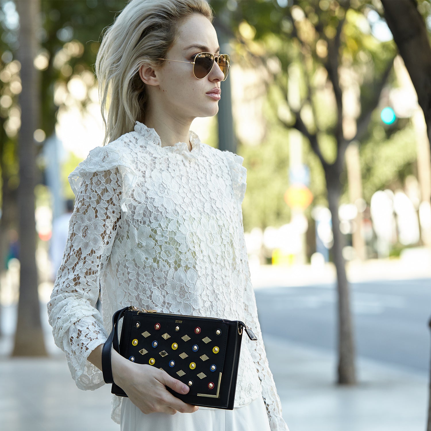 Black Studded Crossbody Clutch with gold chain and leather straps, featuring a chic square silhouette and zipped pockets.