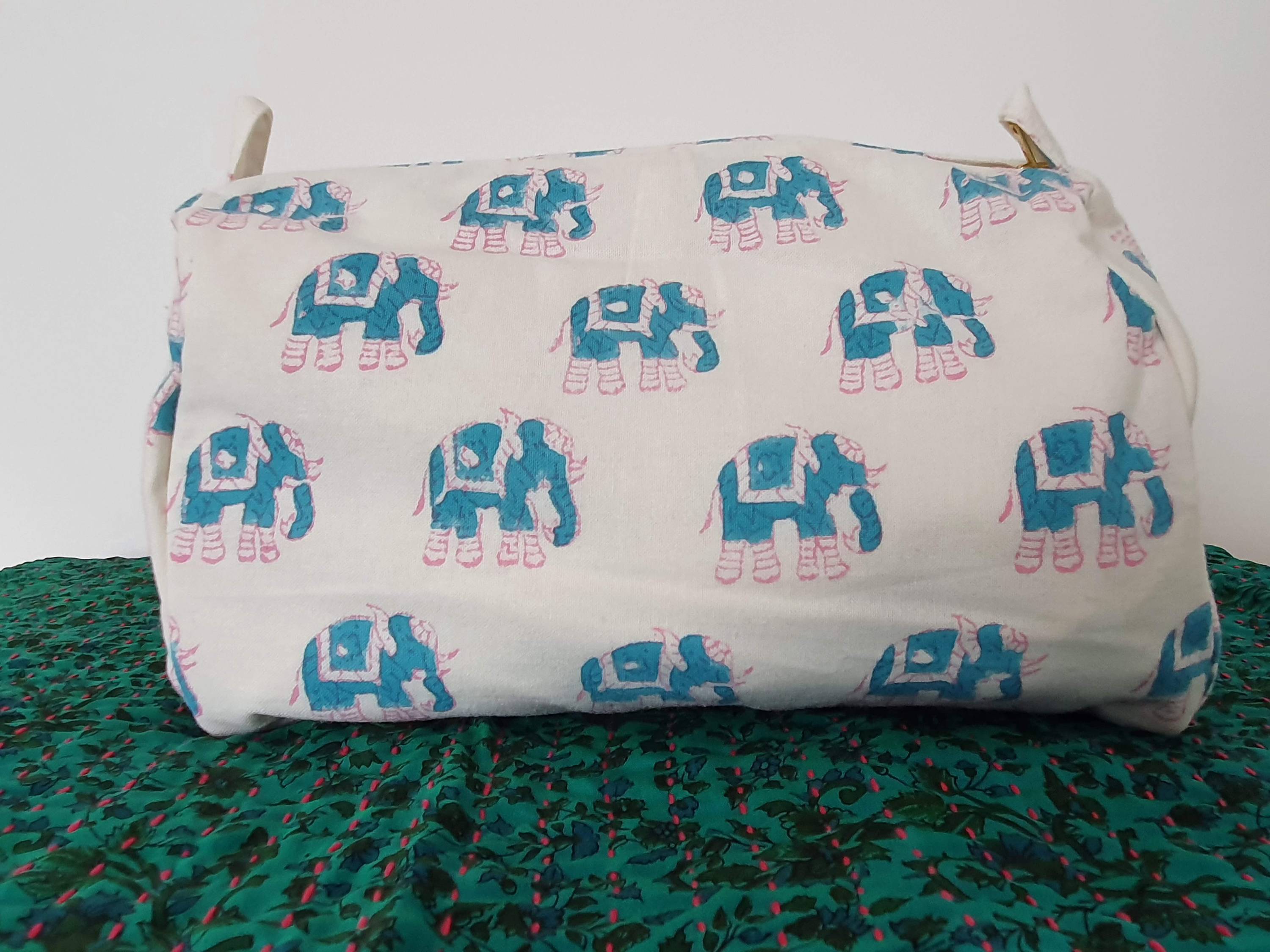 A colorful block-printed elephant toiletry bag featuring vibrant elephants on a cotton fabric, perfect for travel and organization.