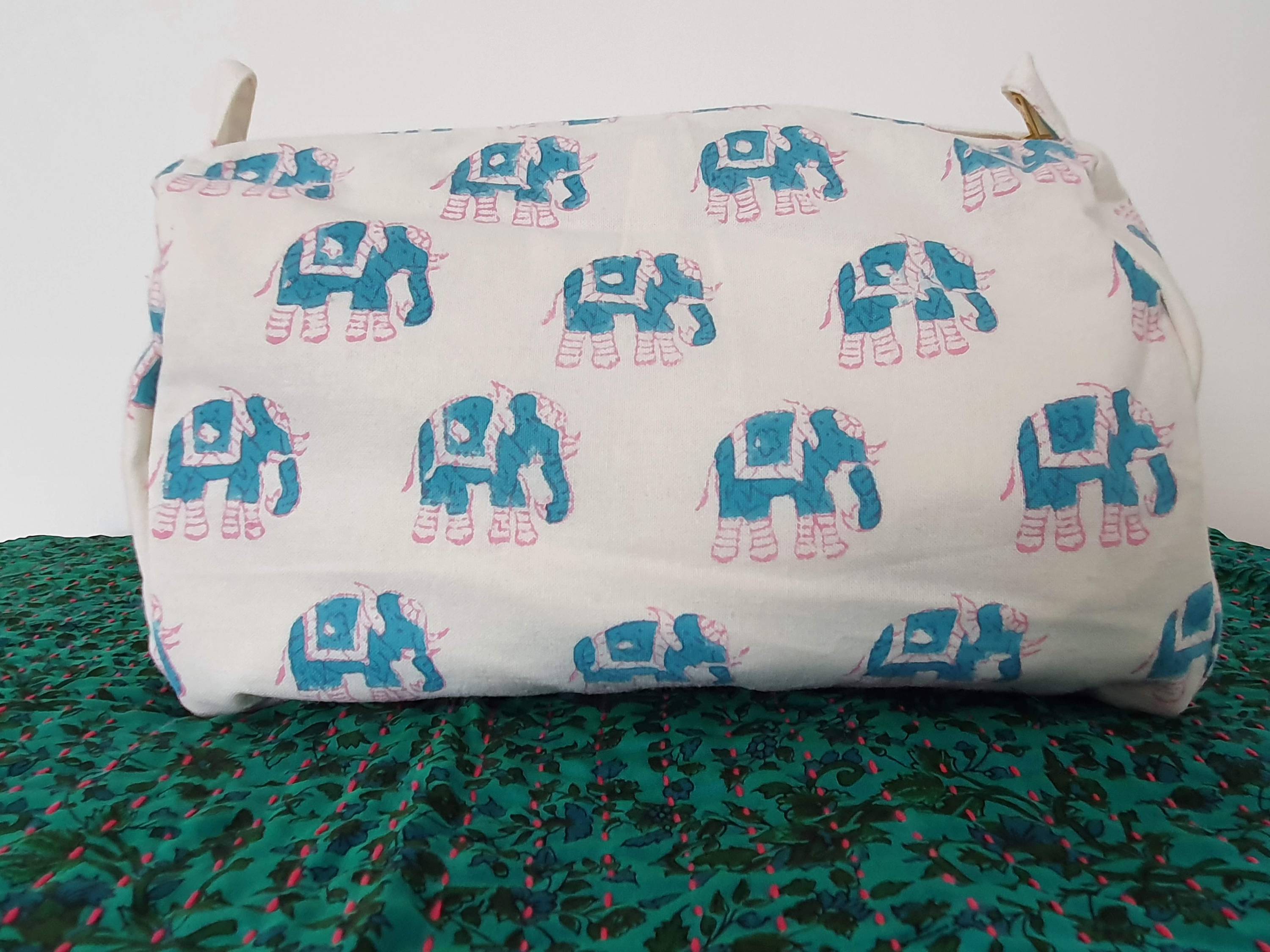 A colorful block-printed elephant toiletry bag featuring vibrant elephants on a cotton fabric, perfect for travel and organization.