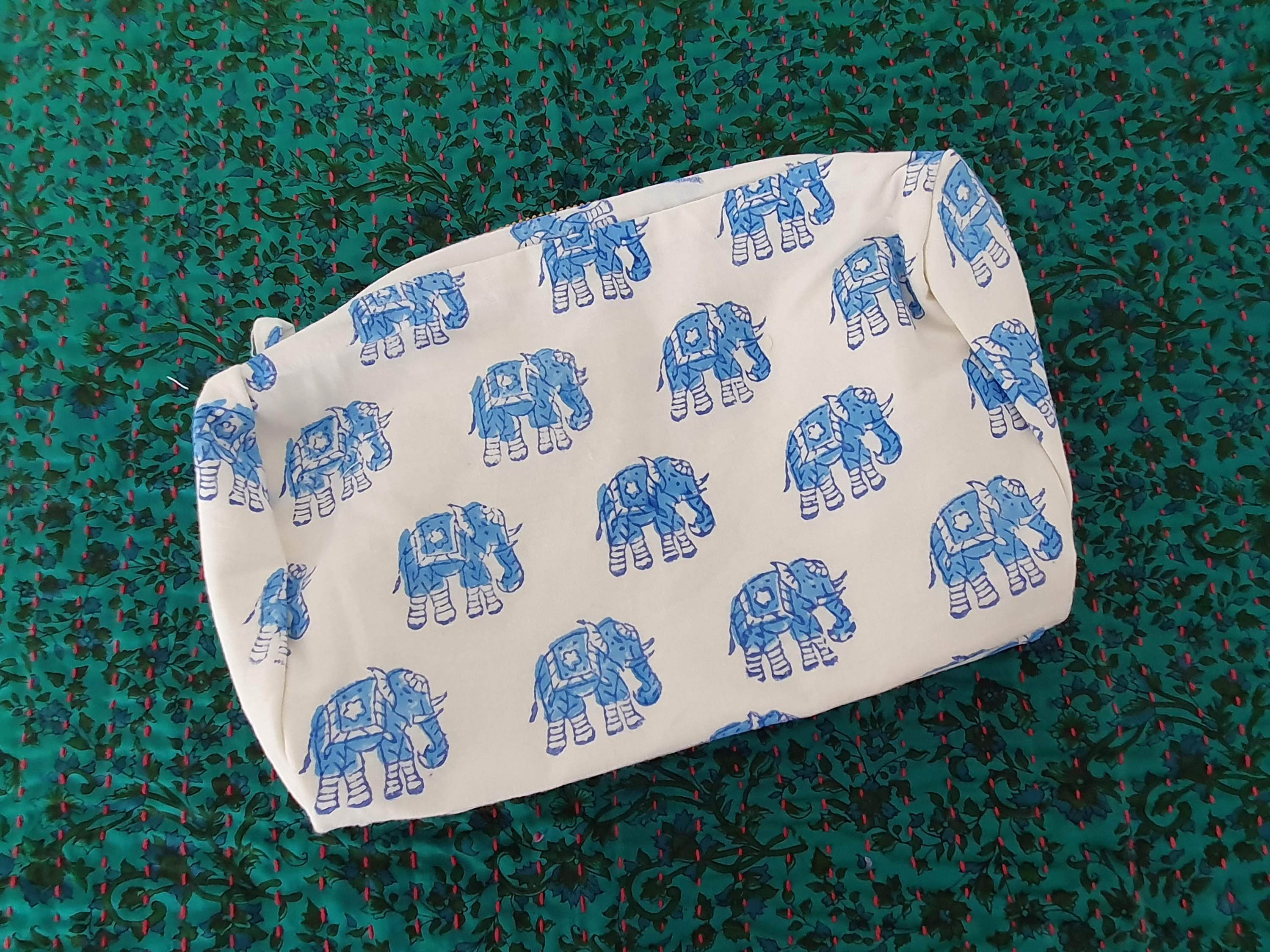 A colorful block-printed elephant toiletry bag featuring vibrant elephants on a cotton fabric, perfect for travel and organization.