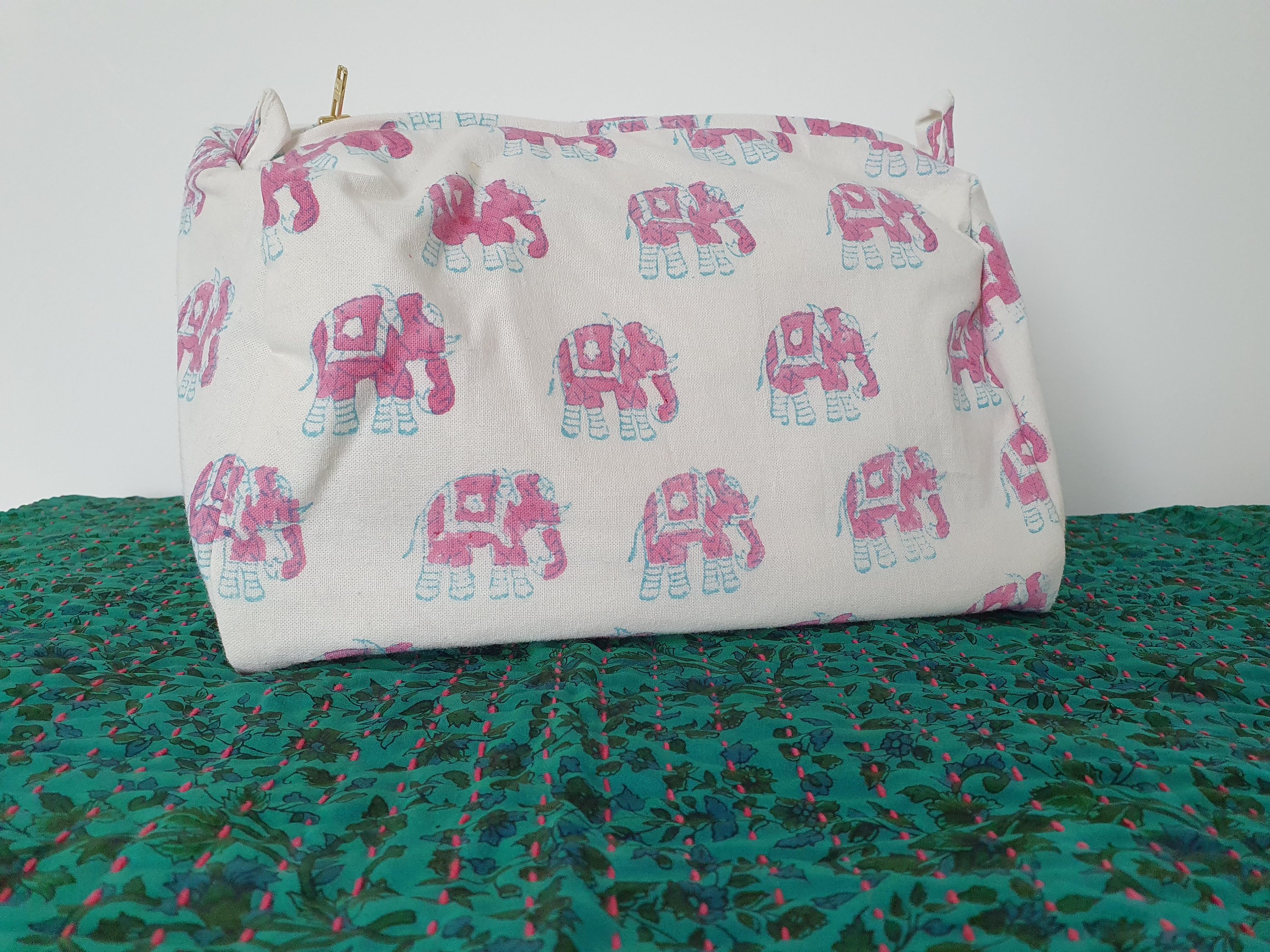 A colorful block-printed elephant toiletry bag featuring vibrant elephants on a cotton fabric, perfect for travel and organization.