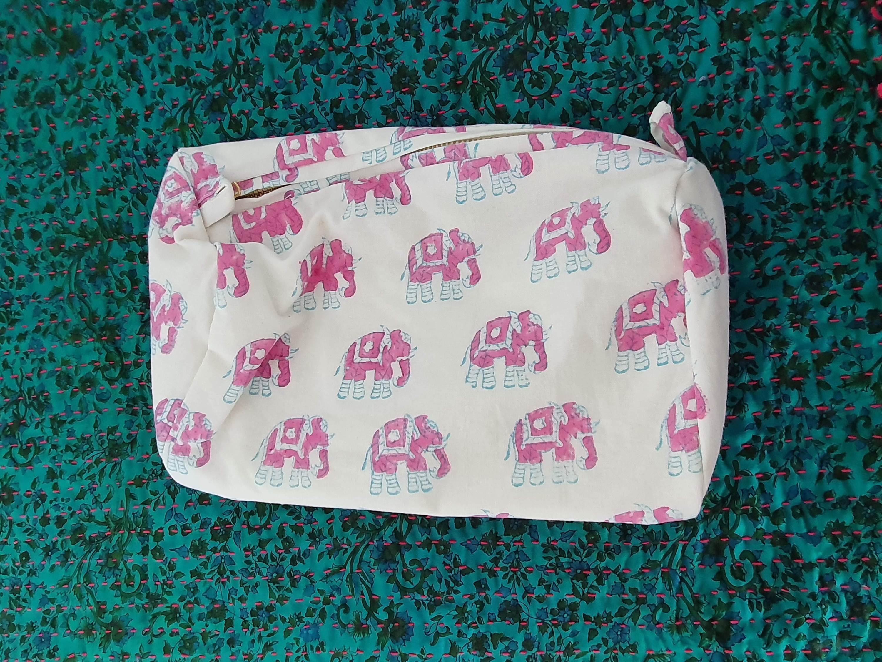 A colorful block-printed elephant toiletry bag featuring vibrant elephants on a cotton fabric, perfect for travel and organization.