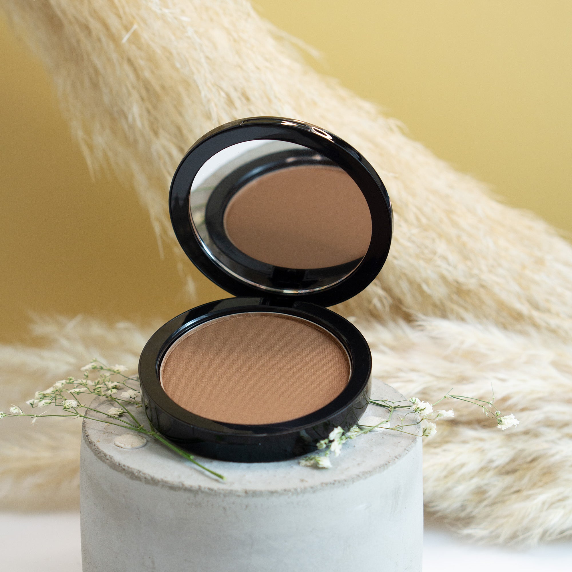 Caramel Bronzer compact showcasing silky texture and rich tones for a natural tan.