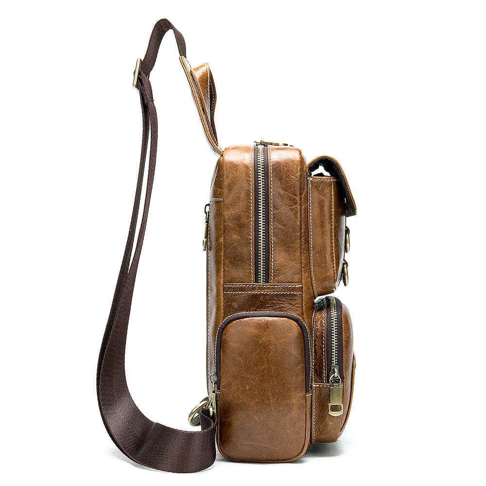 Brown leather chest bag with soft surface, featuring zipper closure and internal pockets for organization.