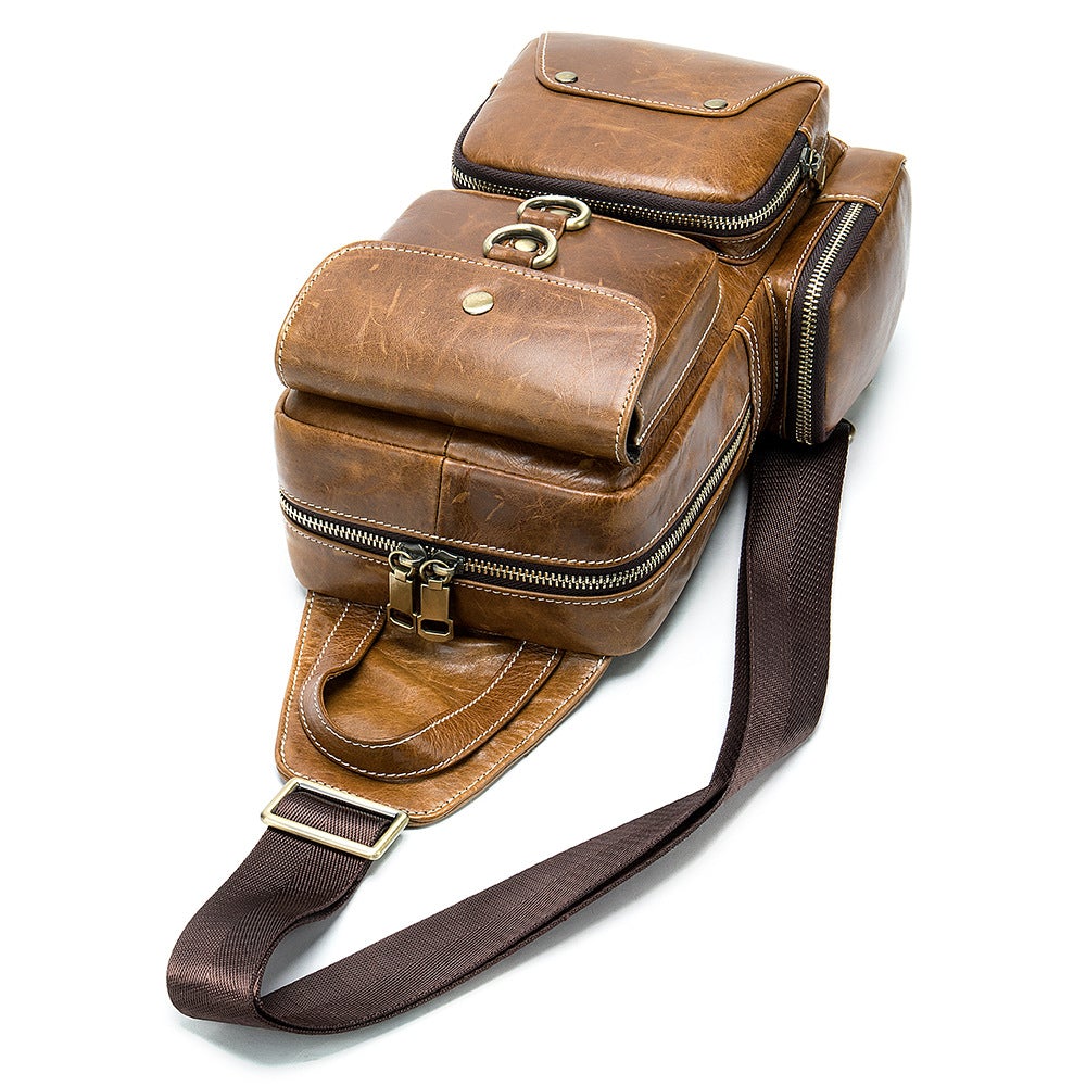 Brown leather chest bag with soft surface, featuring zipper closure and internal pockets for organization.