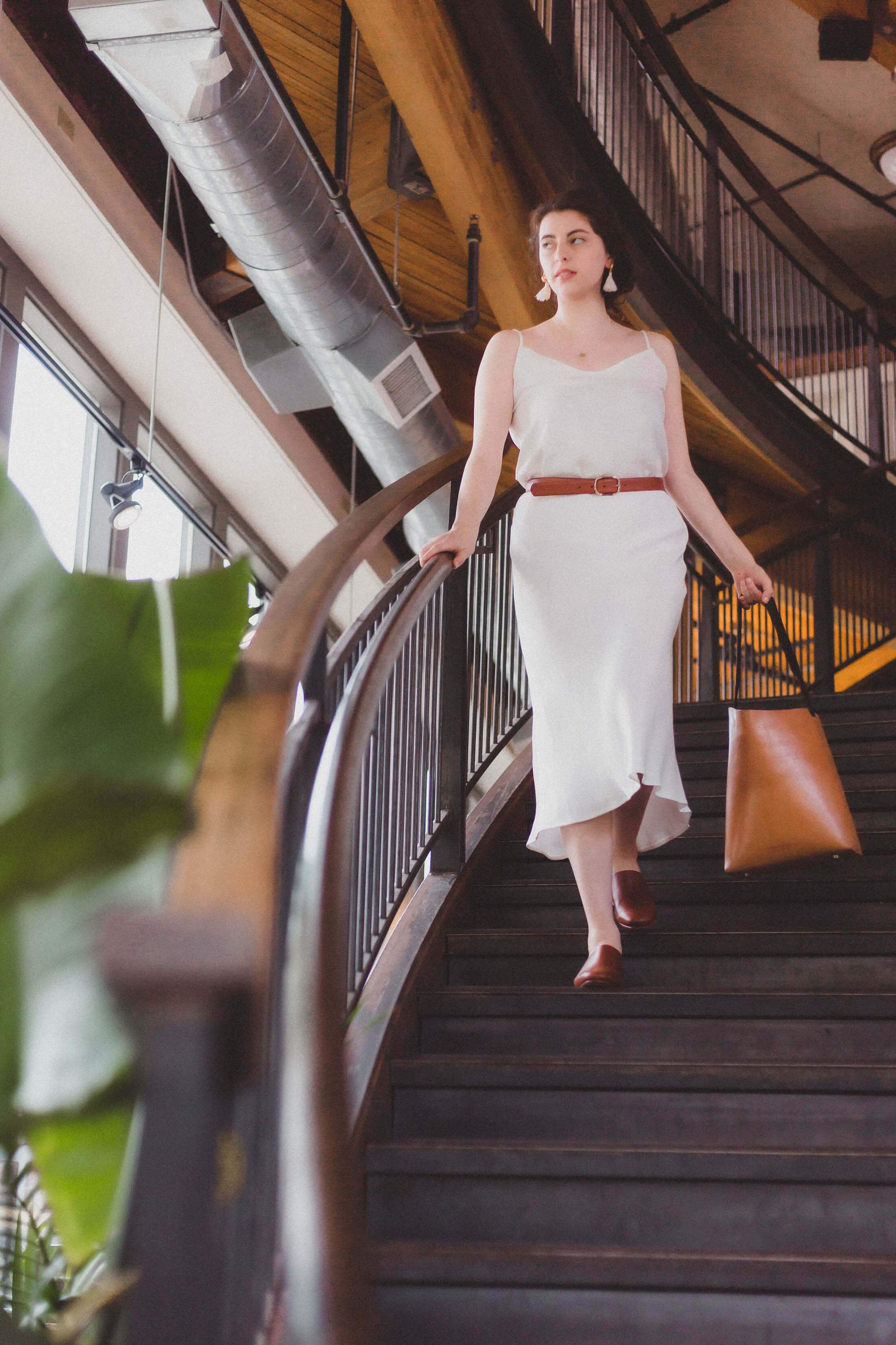 A handcrafted Bucket Tote made from vegtan leather, featuring a minimalist design and unlined interior, perfect for carrying a 13" laptop.