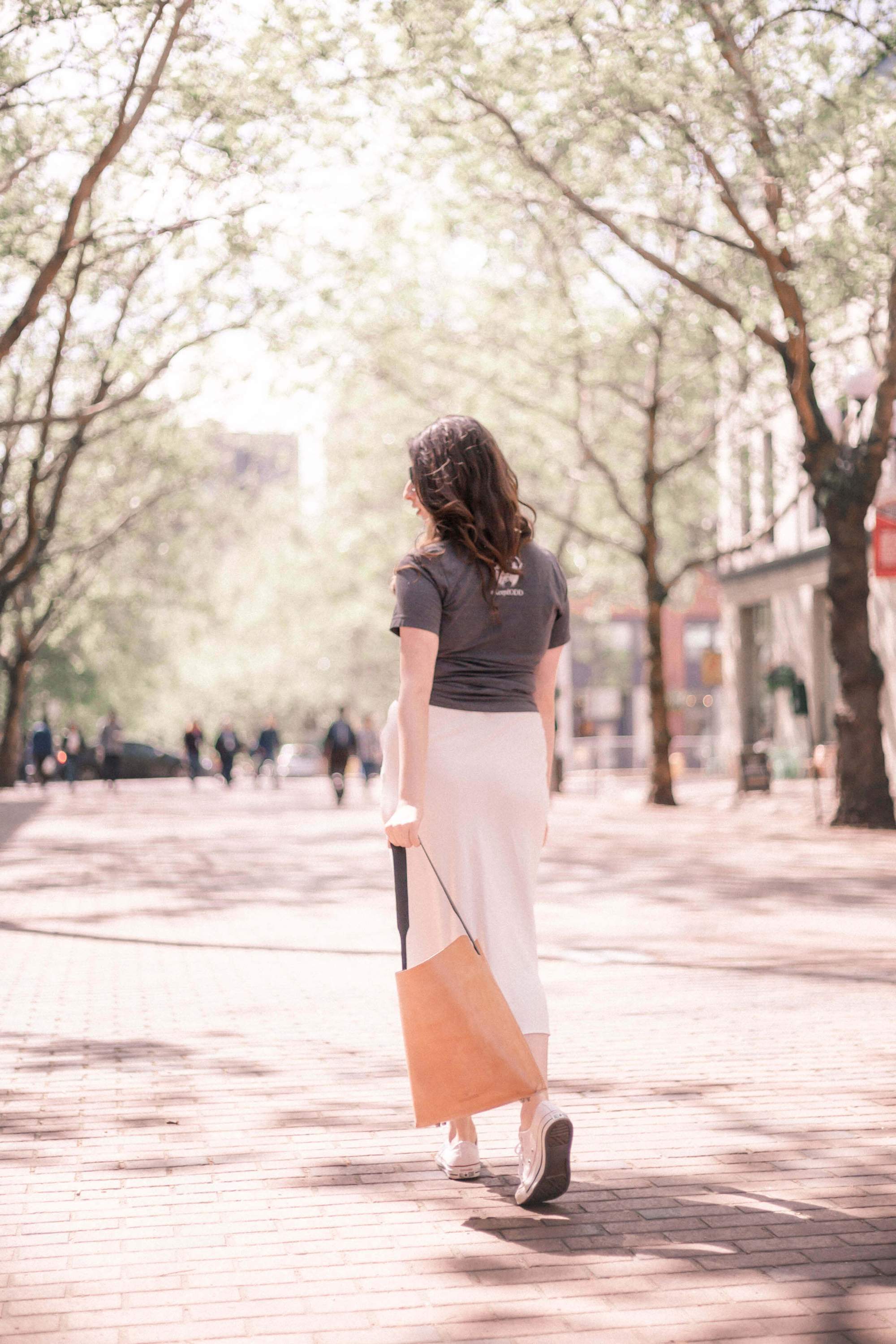 A handcrafted Bucket Tote made from vegtan leather, featuring a minimalist design and unlined interior, perfect for carrying a 13" laptop.