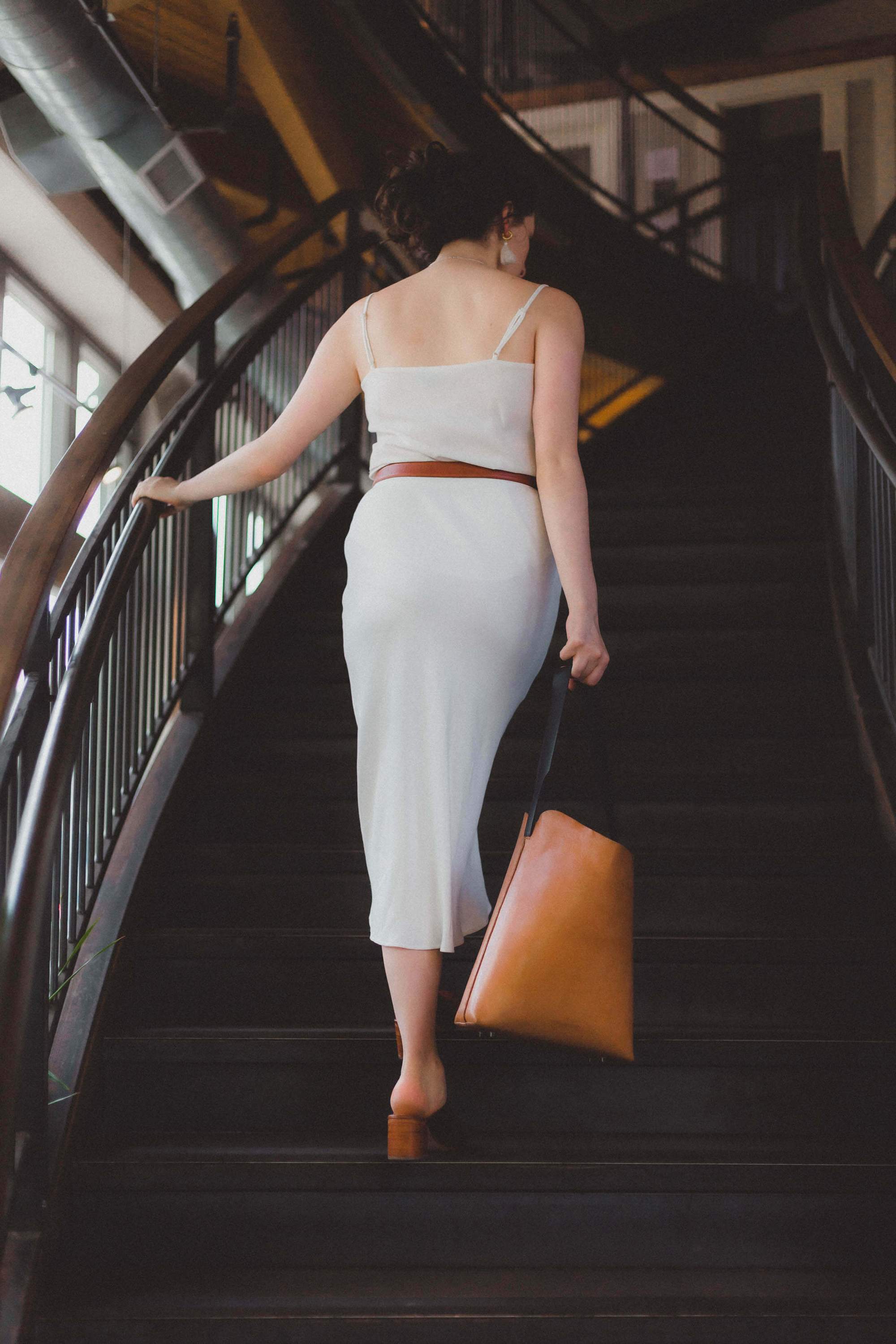 A handcrafted Bucket Tote made from vegtan leather, featuring a minimalist design and unlined interior, perfect for carrying a 13" laptop.