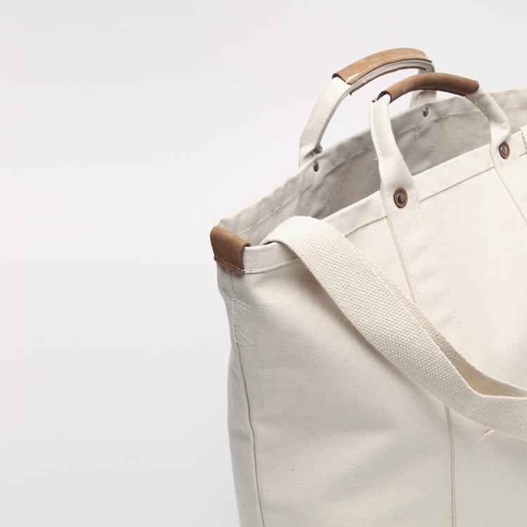 Cargo Carry-On Tote Bag made of heavy cotton canvas with leather accents, featuring a spacious main compartment and outside pockets.