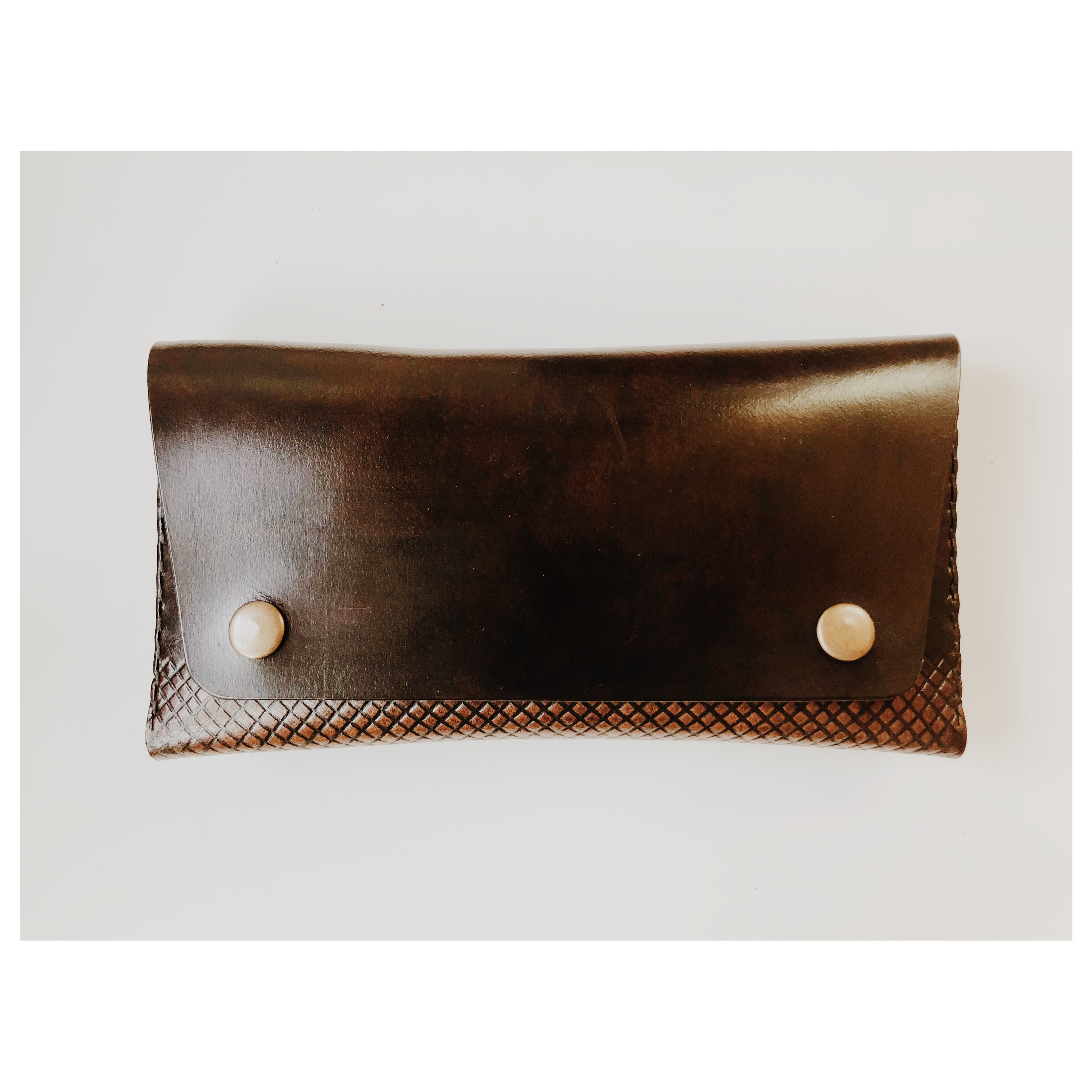 COAL Clutch made from vegetable-tanned leather, featuring a rectangular design with card pockets and a spacious interior for a smartphone.