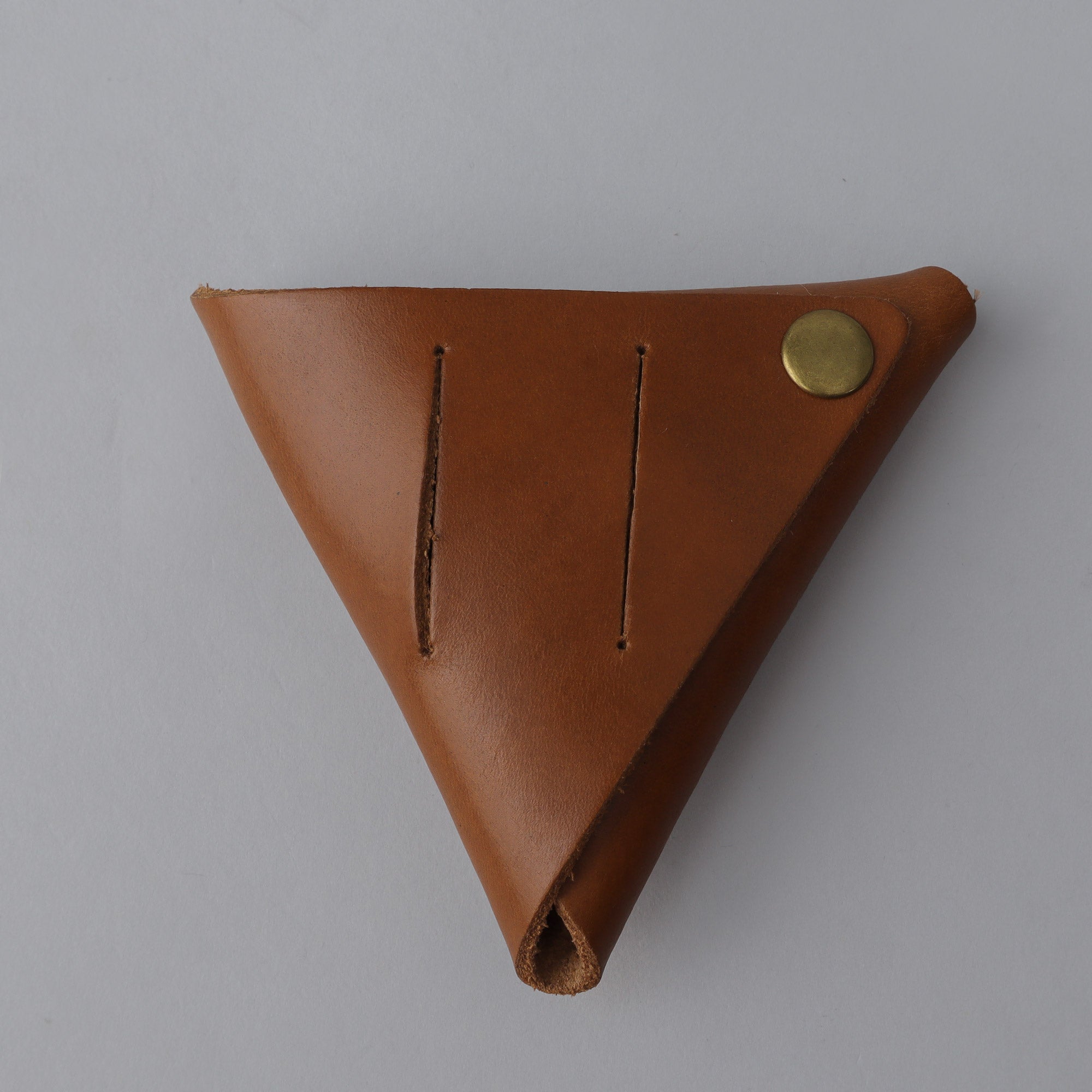 A handcrafted leather coins pouch featuring antique brass hardware, showcasing its elegant design and durable materials.