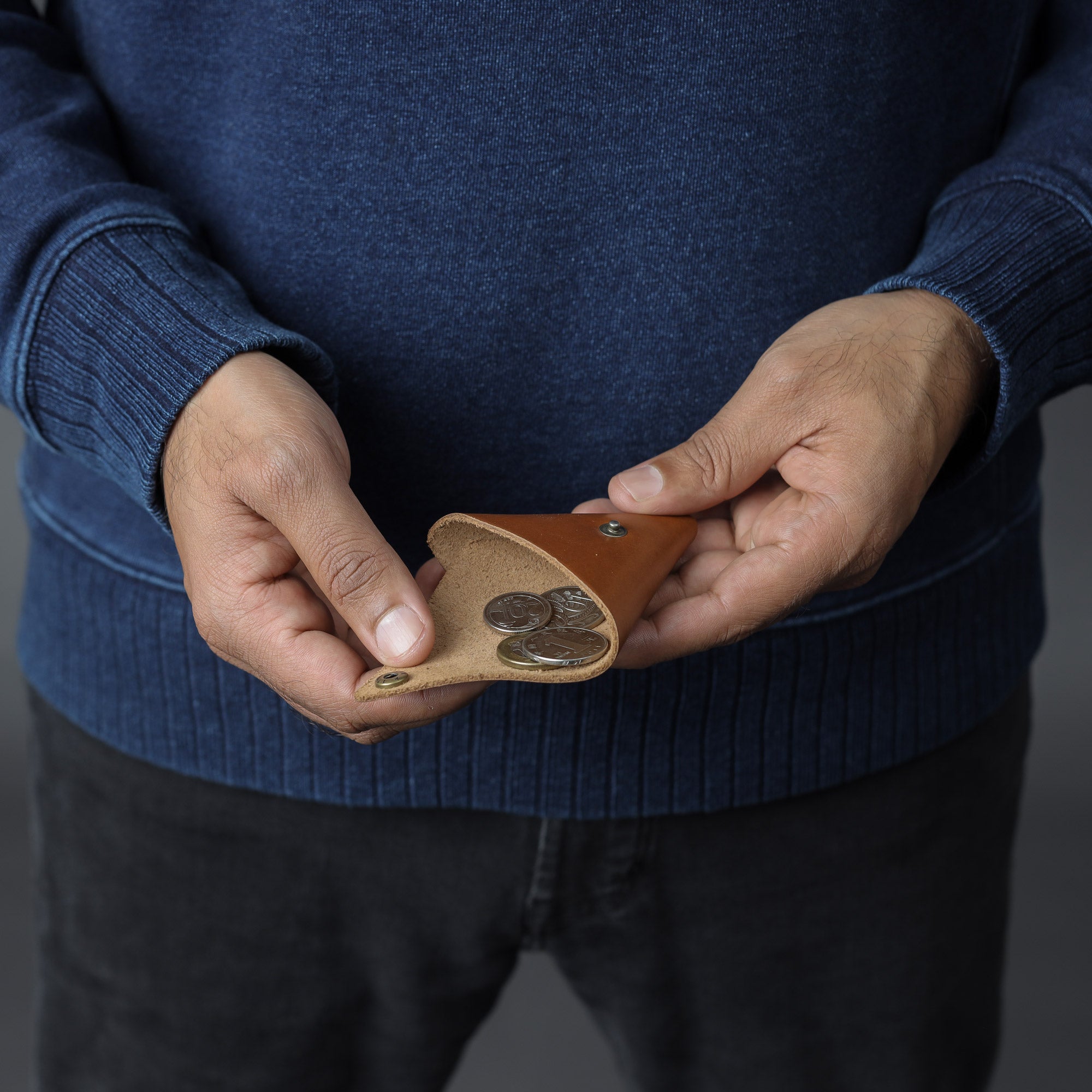 A handcrafted leather coins pouch featuring antique brass hardware, showcasing its elegant design and durable materials.