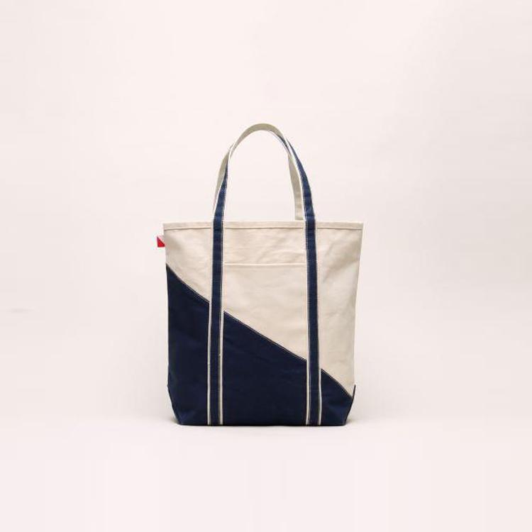 A large contemporary tote bag featuring a diagonal sail design, reinforced handles, and multiple interior pockets for organization.