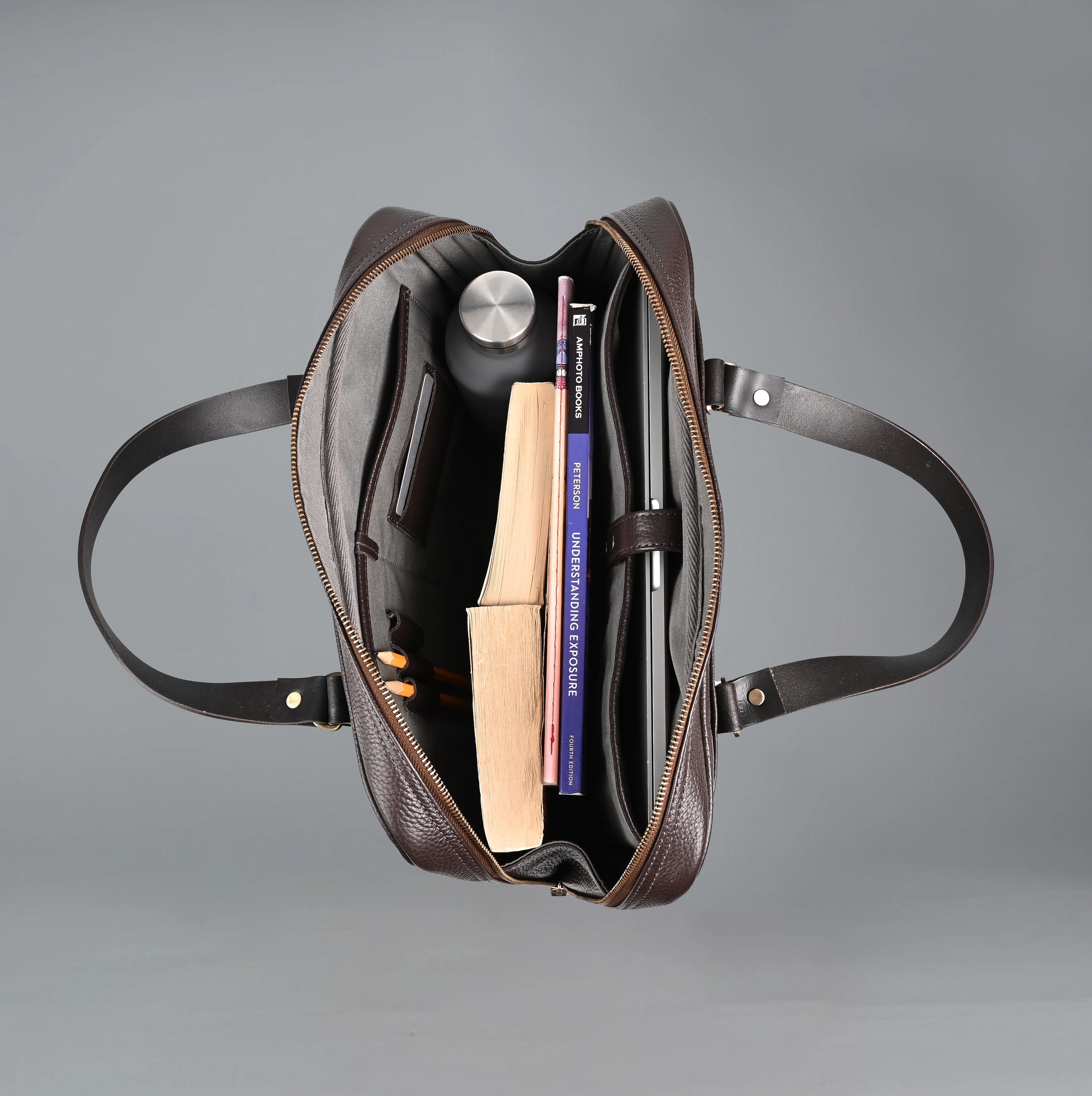 The Creek Briefcase made from premium leather, featuring a padded laptop compartment and multiple storage pockets.