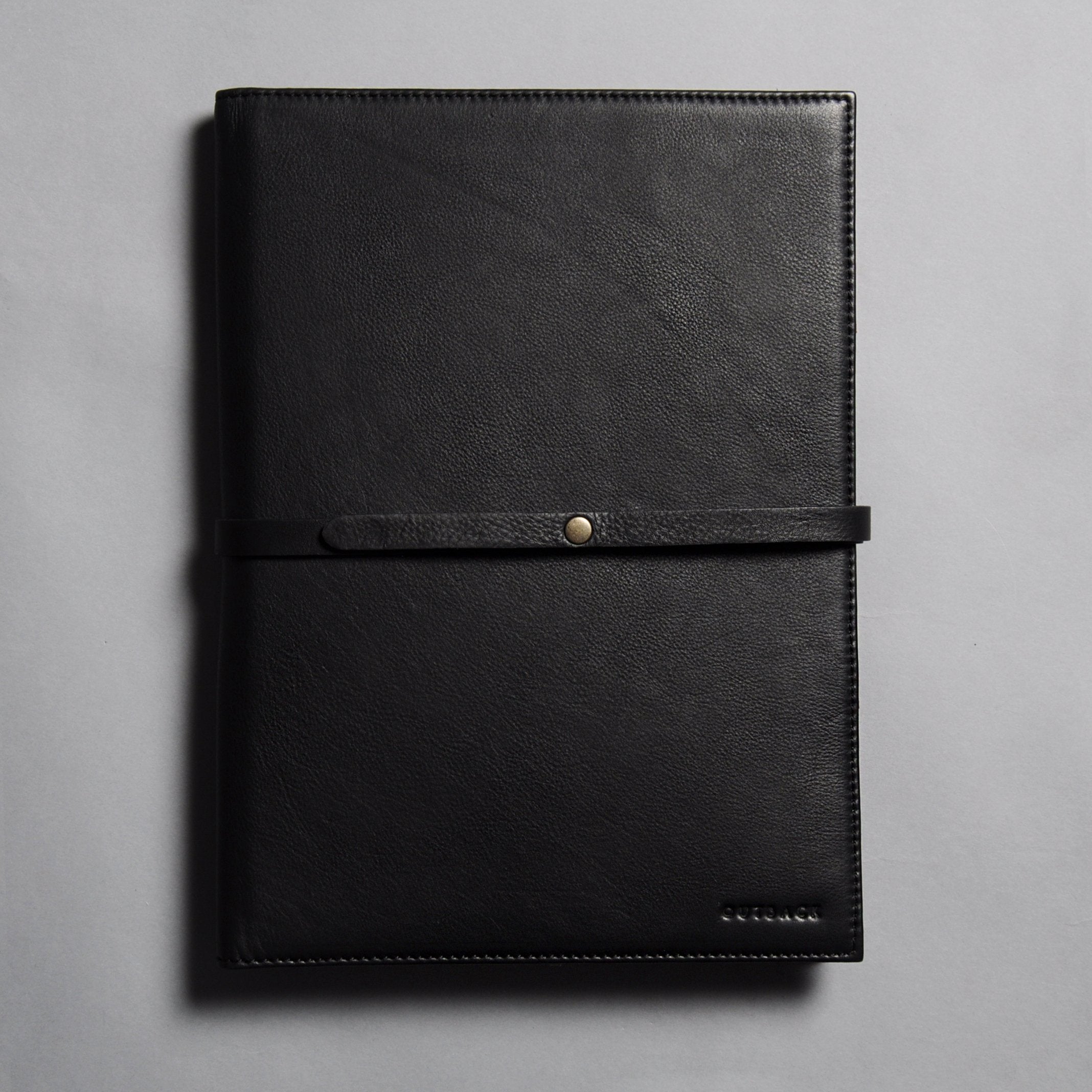 A stylish Daily Organiser made from premium full grain leather, featuring compartments for A4 sheets and an iPad, with brass rivets and antique finish hardware.