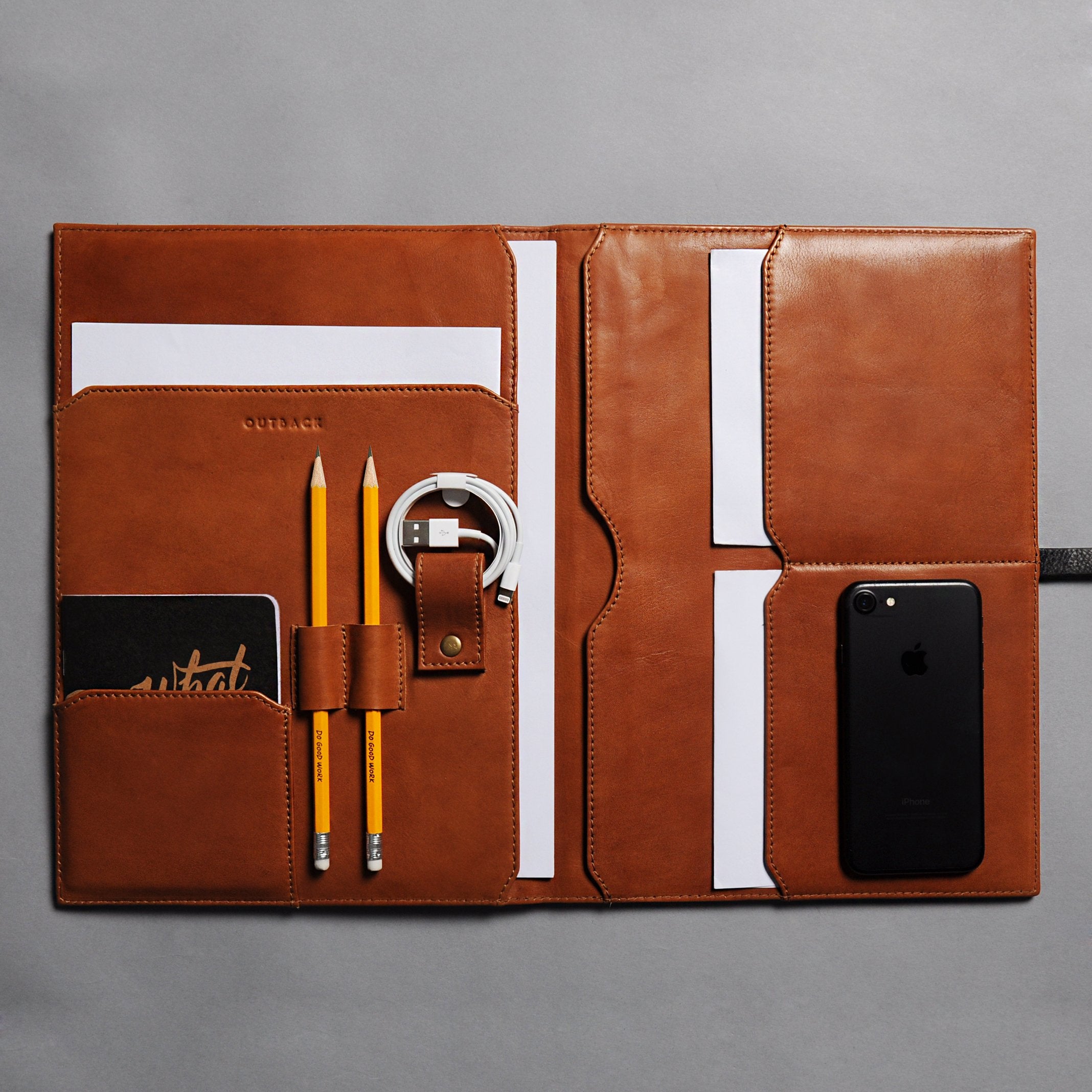 A stylish Daily Organiser made from premium full grain leather, featuring compartments for A4 sheets and an iPad, with brass rivets and antique finish hardware.