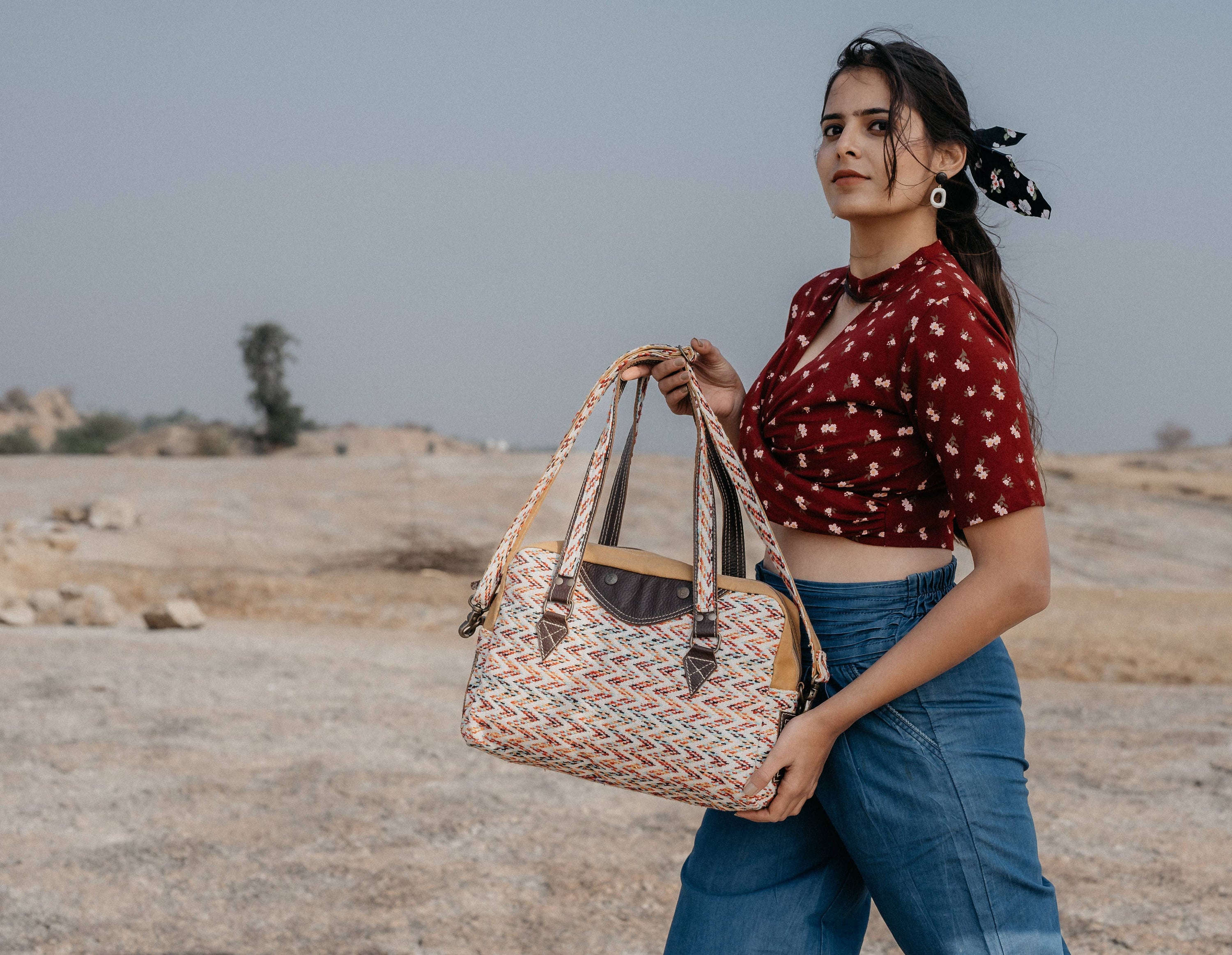 A stylish Dashing Duffle Bag made from rug, leather, and upcycled canvas, showcasing its unique design and vibrant colors.