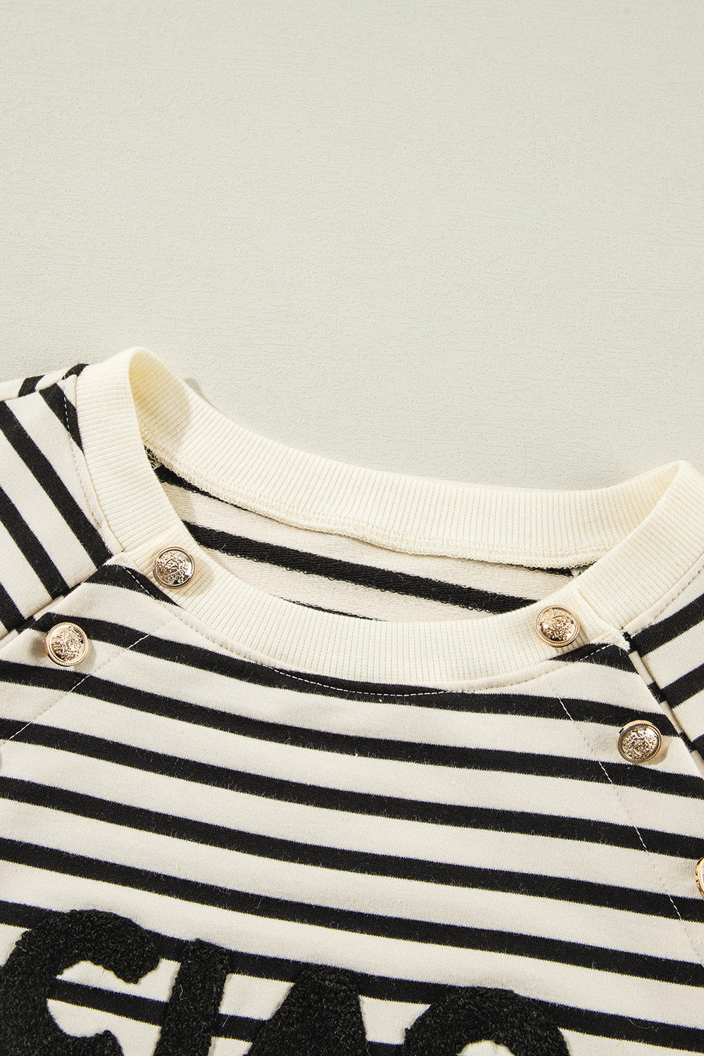 A stylish Decorative Button Striped Long Sleeve Sweatshirt featuring decorative buttons, soft fabric, and a trendy striped pattern.