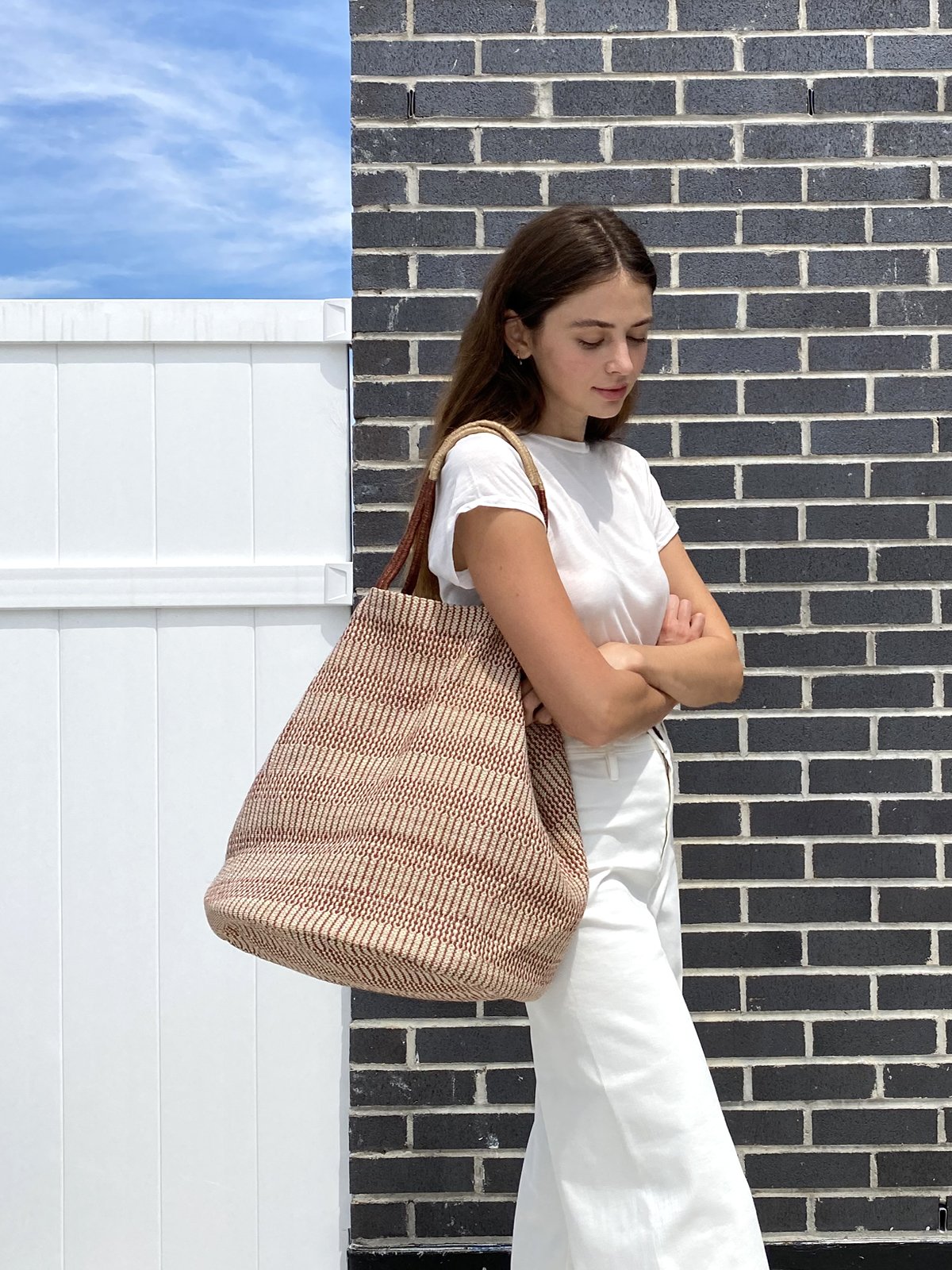 Dobi Shoulder Tote in Brown, featuring a spacious design and round bottom, handmade from jute-cotton fabric with off-white handle accents.