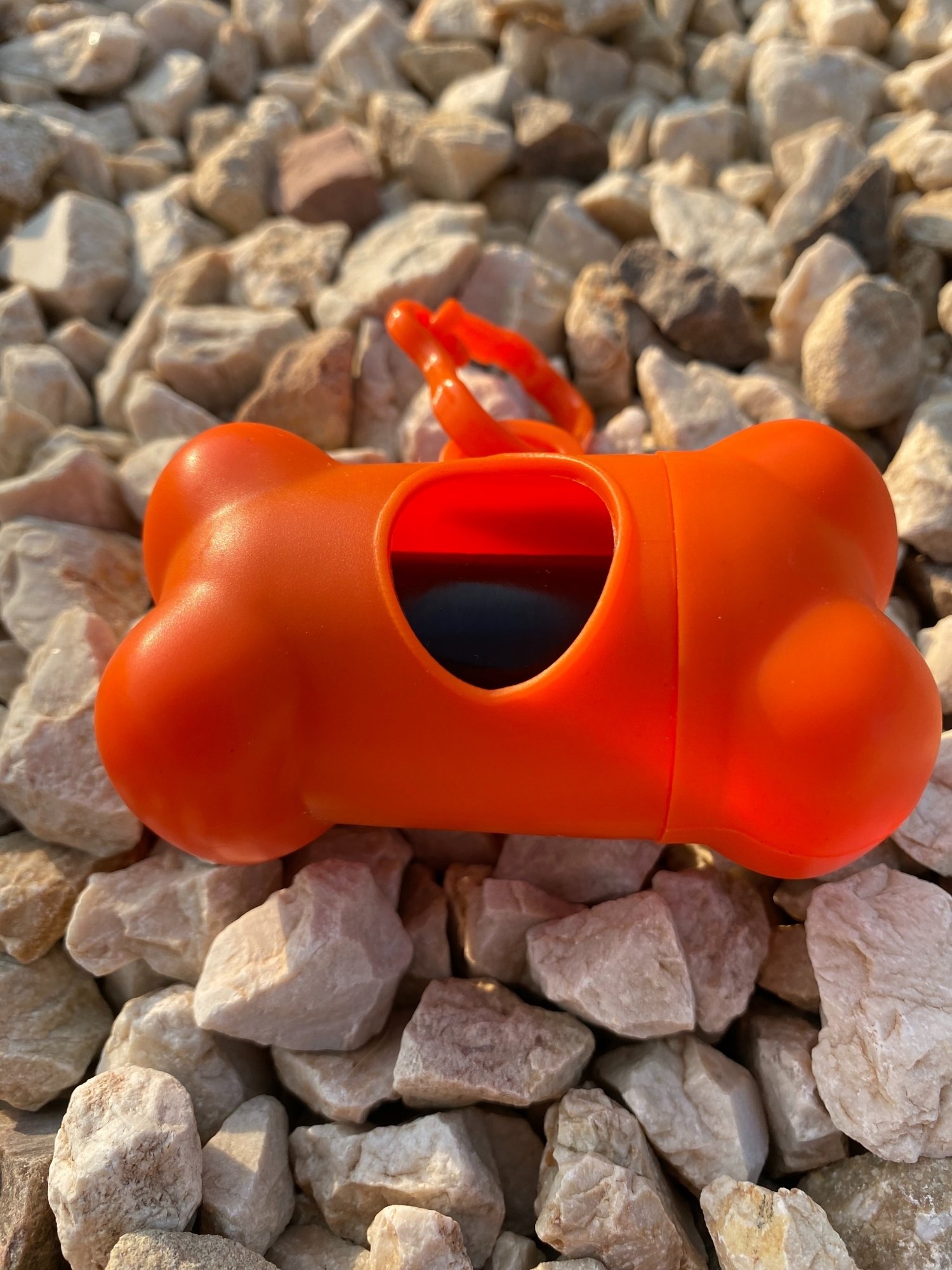 DogBone Poop Bag Dispenser in various colors with bags attached, designed for easy cleanup during dog walks.