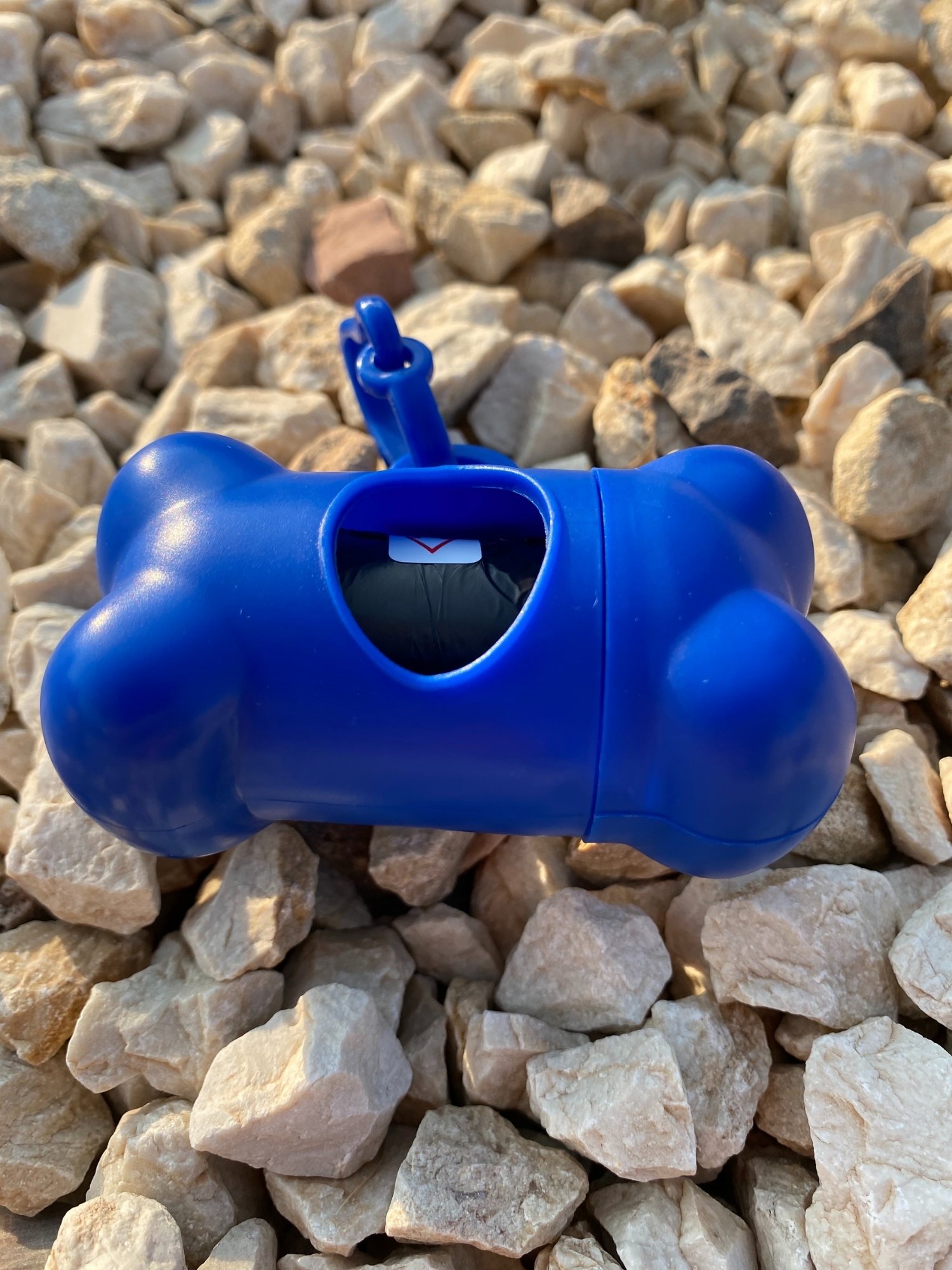 DogBone Poop Bag Dispenser in various colors with bags attached, designed for easy cleanup during dog walks.